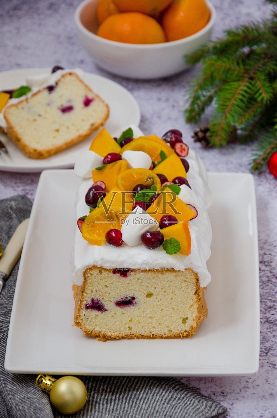 圣诞蛋糕，上面有棉花糖糖霜，蔓越莓，柿子和焦糖橘子。照片摄影图片