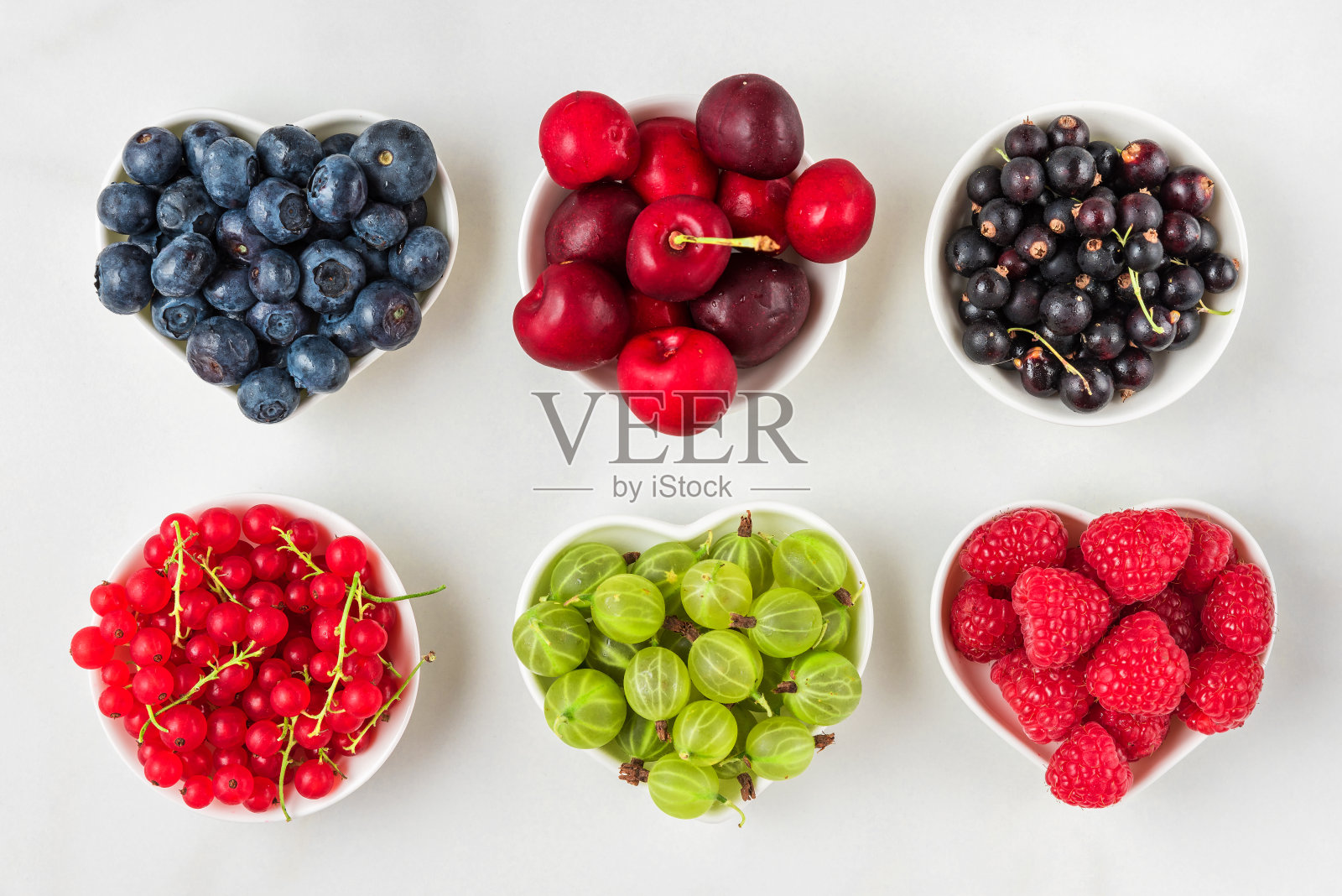 新鲜的夏季浆果覆盆子，樱桃，蓝莓，红加仑子，黑加仑子和醋栗白色背景照片摄影图片