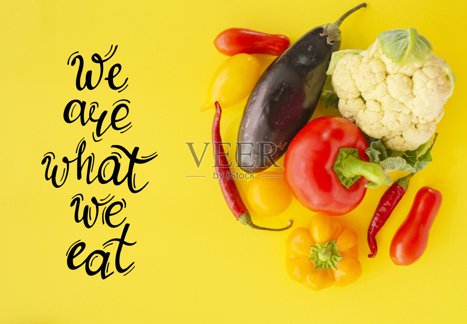 我们吃什么就是什么，手写的字母。黄色背景上的新鲜蔬菜。有机食品与健康营养。收获的节日，秋天的季节。照片摄影图片
