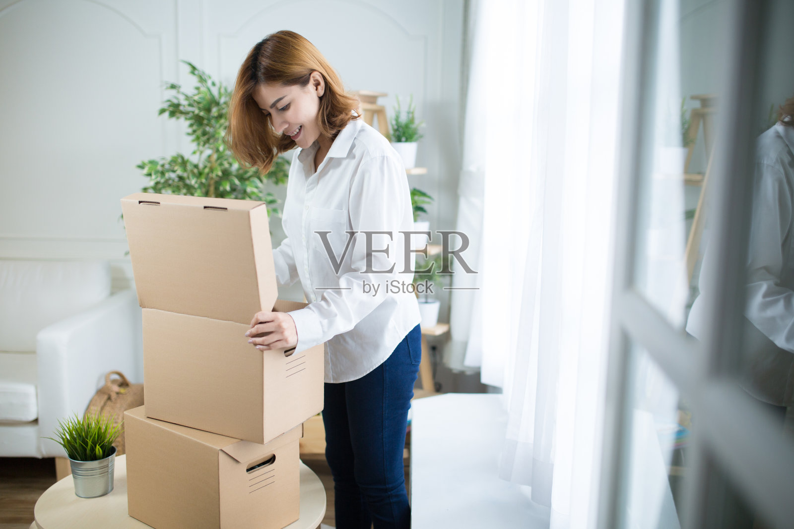 家庭、邮政、快递和幸福理念——微笑的年轻女子在家里打开纸箱，闪耀光芒照片摄影图片