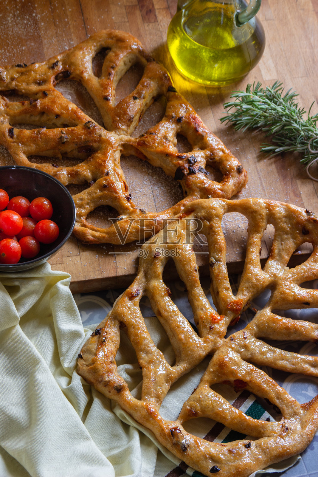 顶视图的福加斯法国面包与太阳干番茄和橄榄在木制背景。照片摄影图片