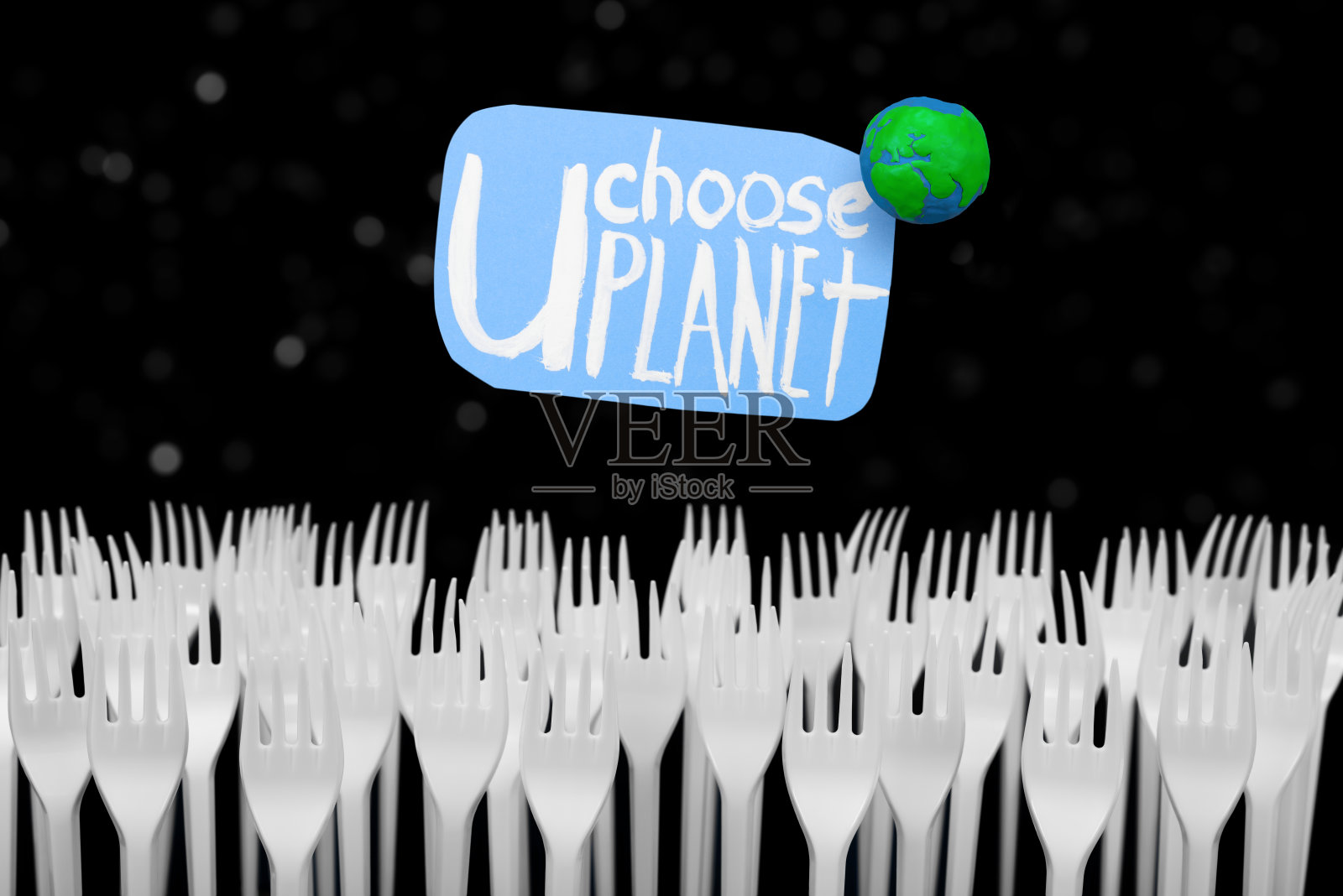 橡皮泥地球手工和贴纸生态文字，上面的塑料叉白星散焦背景。生态概念的地球一小时，地球日，海洋日和其他ECO日期。照片摄影图片