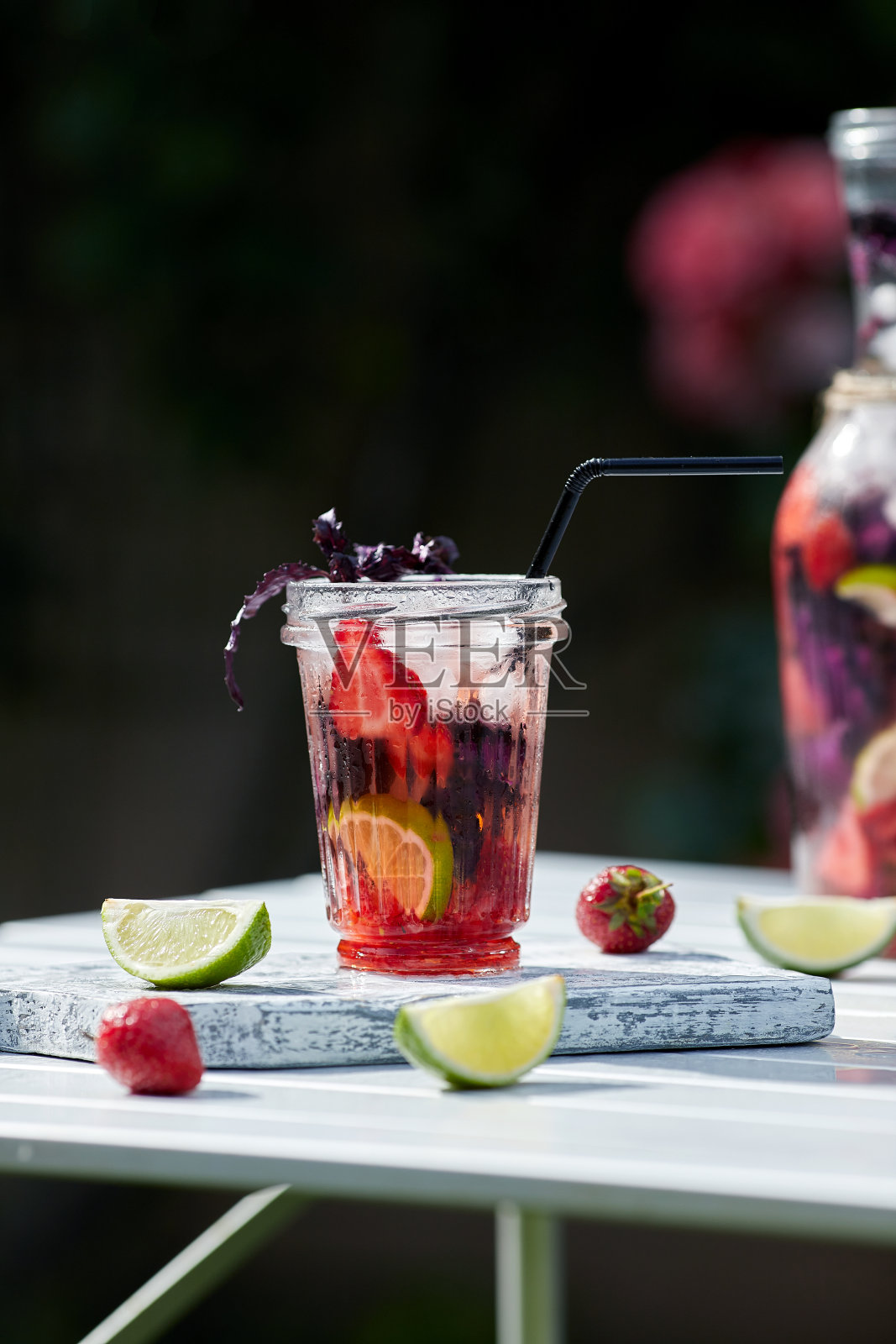 美味清爽的柠檬水，加入罗勒，酸橙和草莓。夏日饮冰。家里做的生产。照片摄影图片