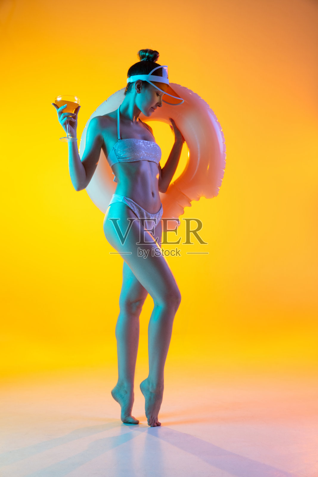 时尚肖像性感的女孩在时尚的泳衣摆姿势在明亮的黄色背景。夏季,海滩季节照片摄影图片