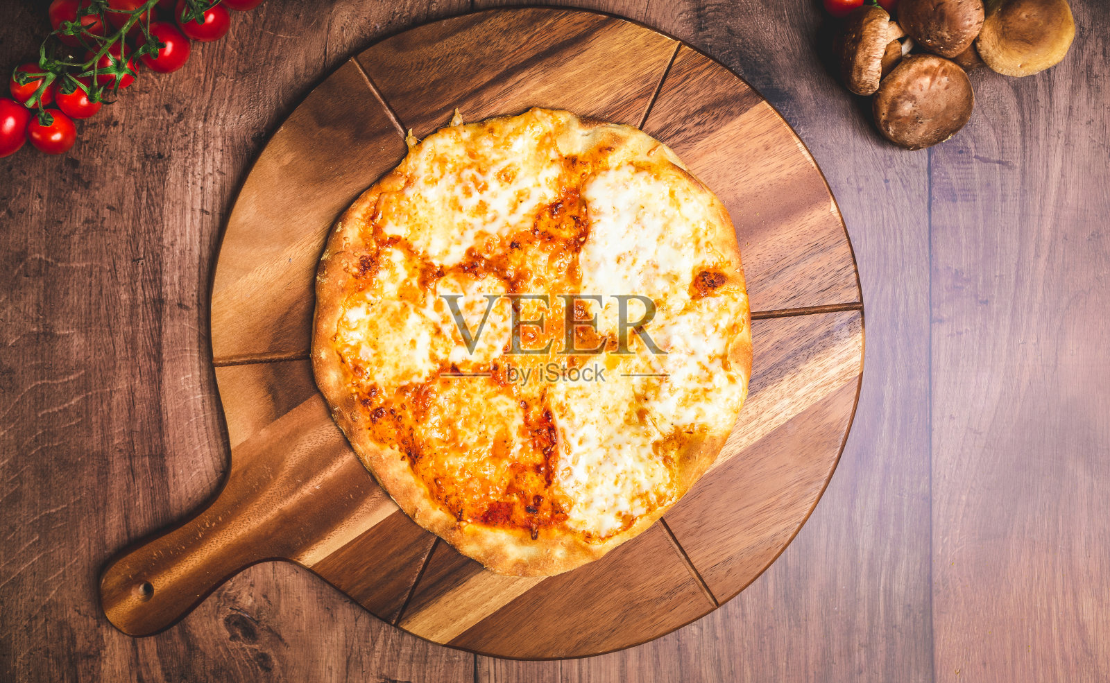 自制新鲜出炉的玛格丽塔披萨，上面是融化的马苏里拉奶酪，放在木板上，还有很多装饰蔬菜。新鲜热披萨的概念，为您的文本/装饰的自由空间。照片摄影图片