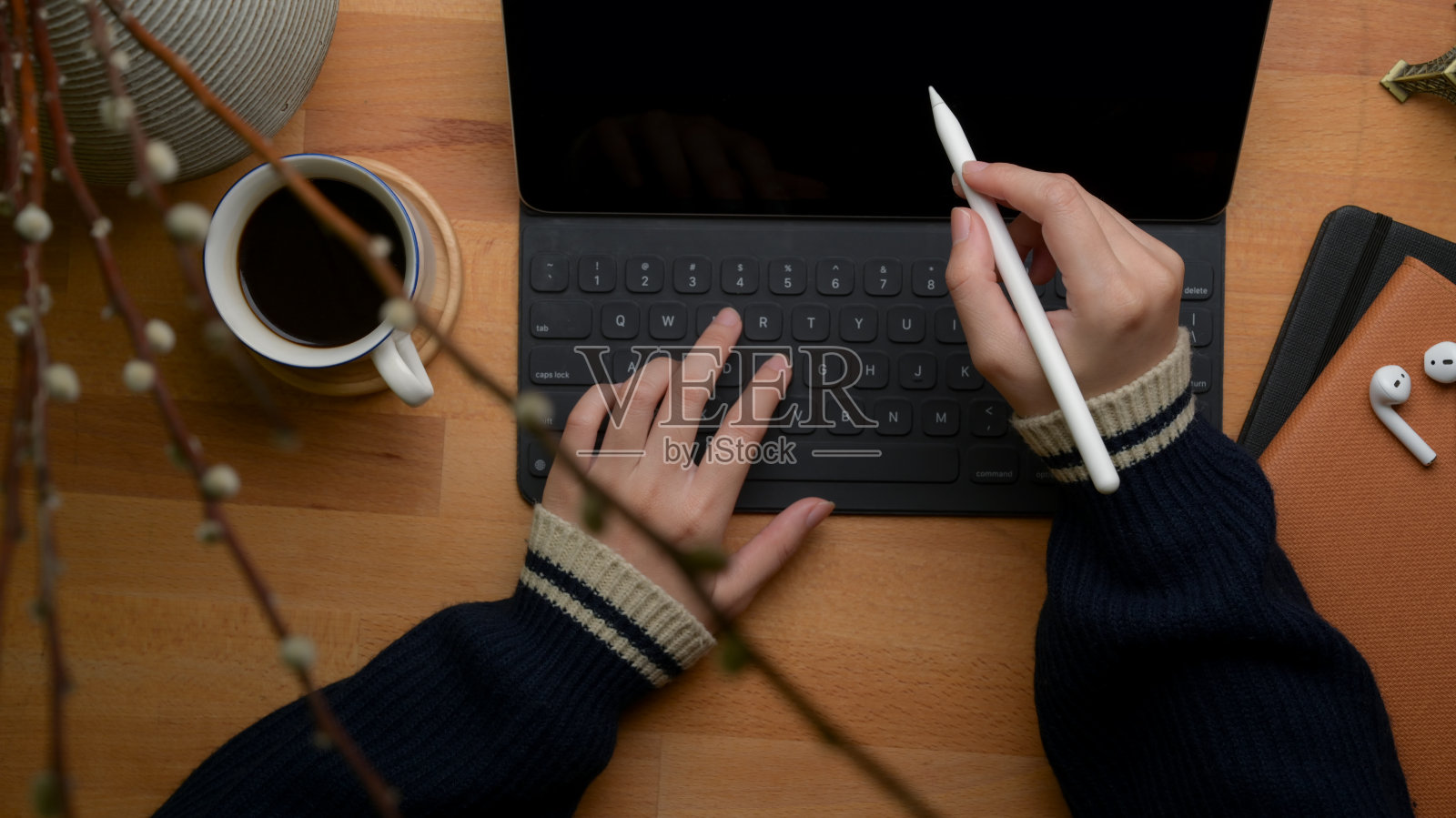 女性自由职业者使用数字平板电脑，咖啡杯，日程表和家庭办公桌上的装饰照片摄影图片