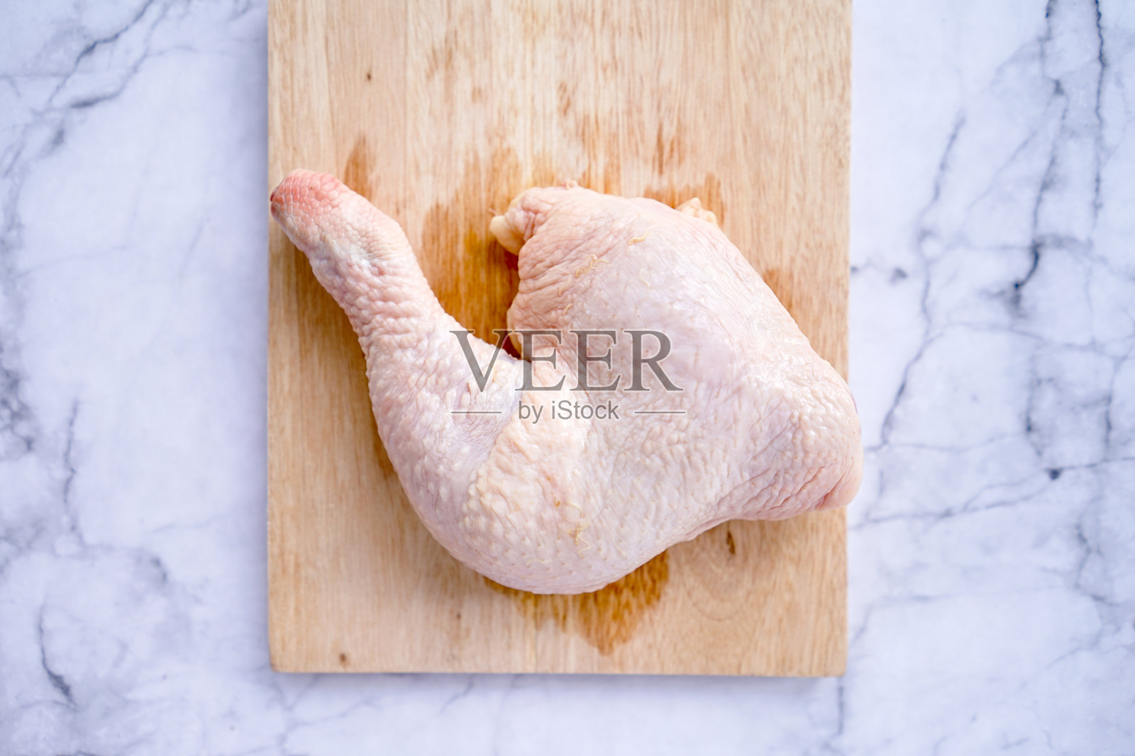 生鸡大腿肉放在木砧板上。烹饪鸡肉。生鸡肉。健康食品的概念照片摄影图片
