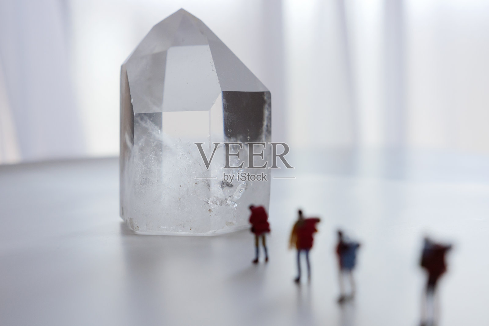 一个攀爬者试图爬上锋利的水晶的微型娃娃照片摄影图片