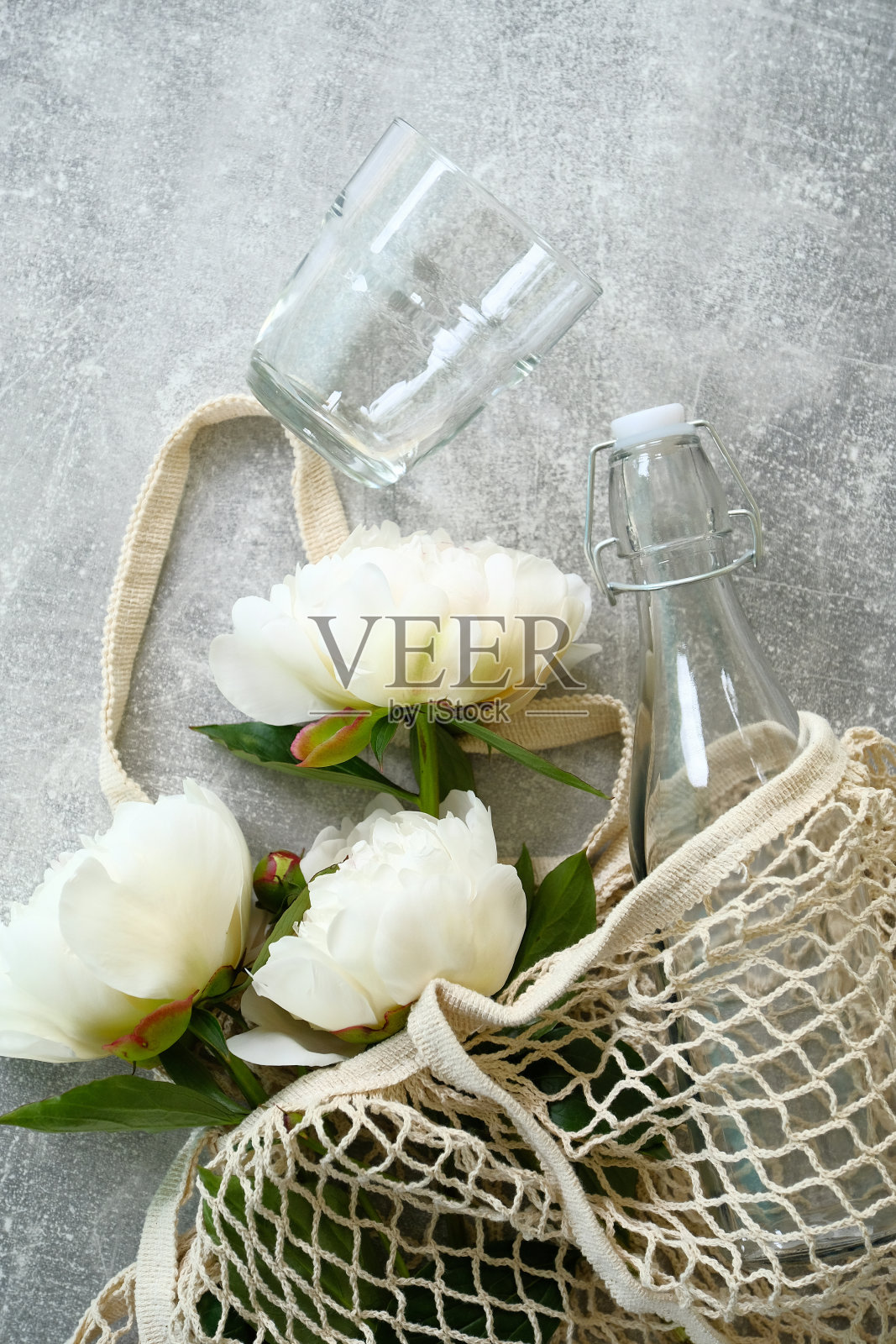 环保环保购物袋，牡丹花，玻璃和瓶子的石材背景。平躺，俯视图。零浪费，可持续的生活理念。照片摄影图片