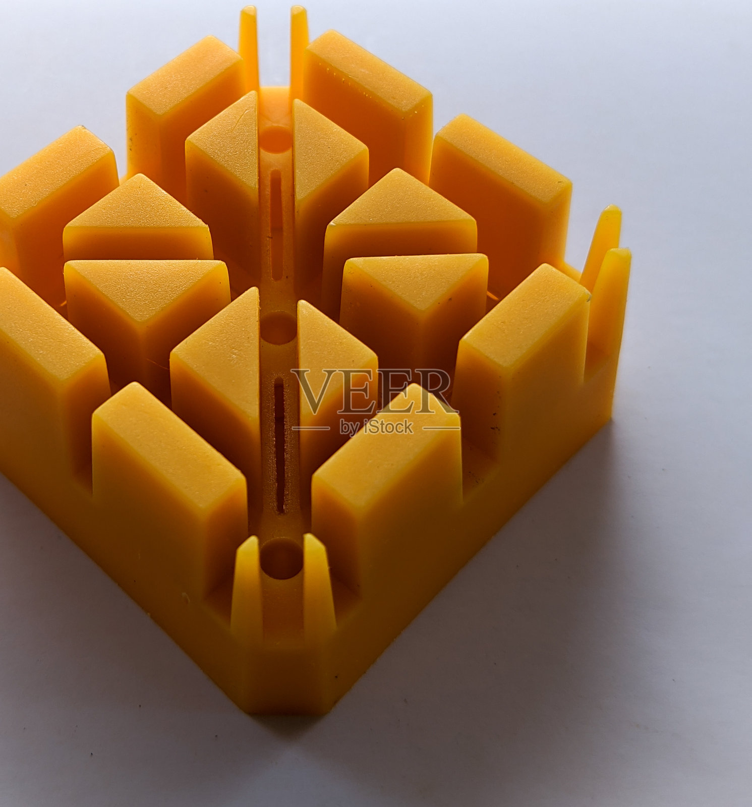 黄色塑料块与花纹槽，以白色背景照片摄影图片