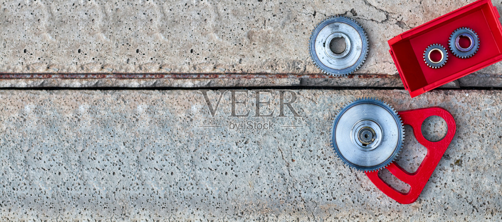 混凝土背景上带红笔的齿轮照片摄影图片
