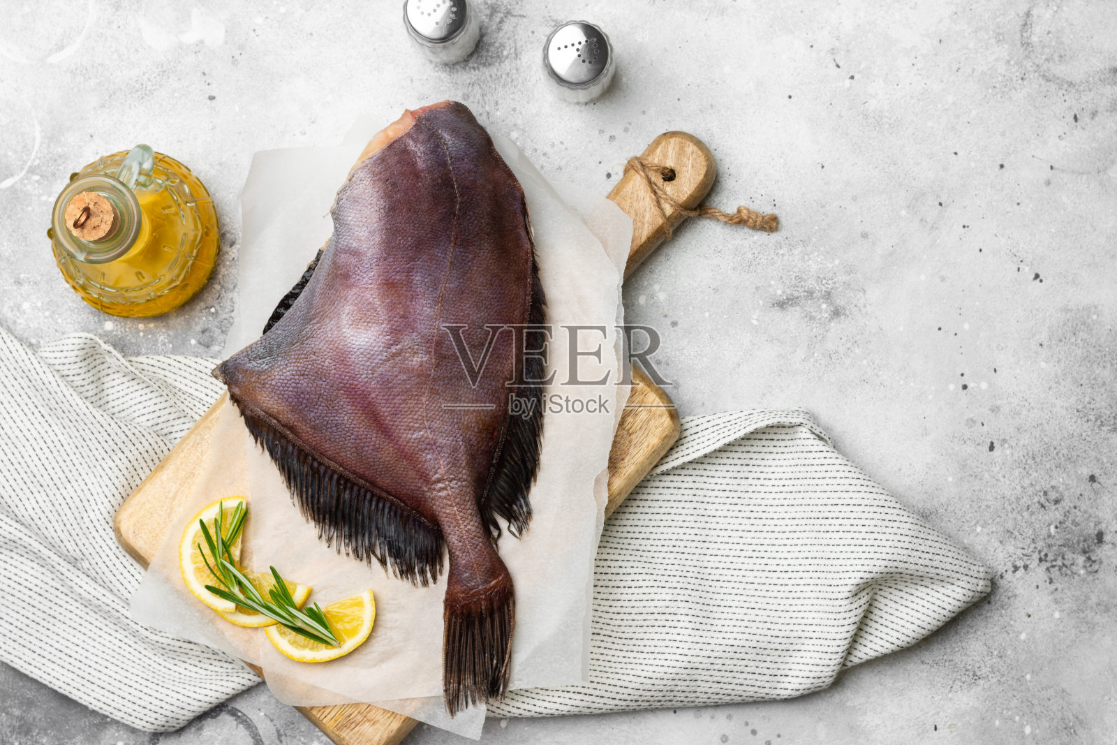 多莉的生鱼片放在浅灰色的餐桌上的一块木板上。多丽鱼特写。带有文本空间的俯视图照片摄影图片