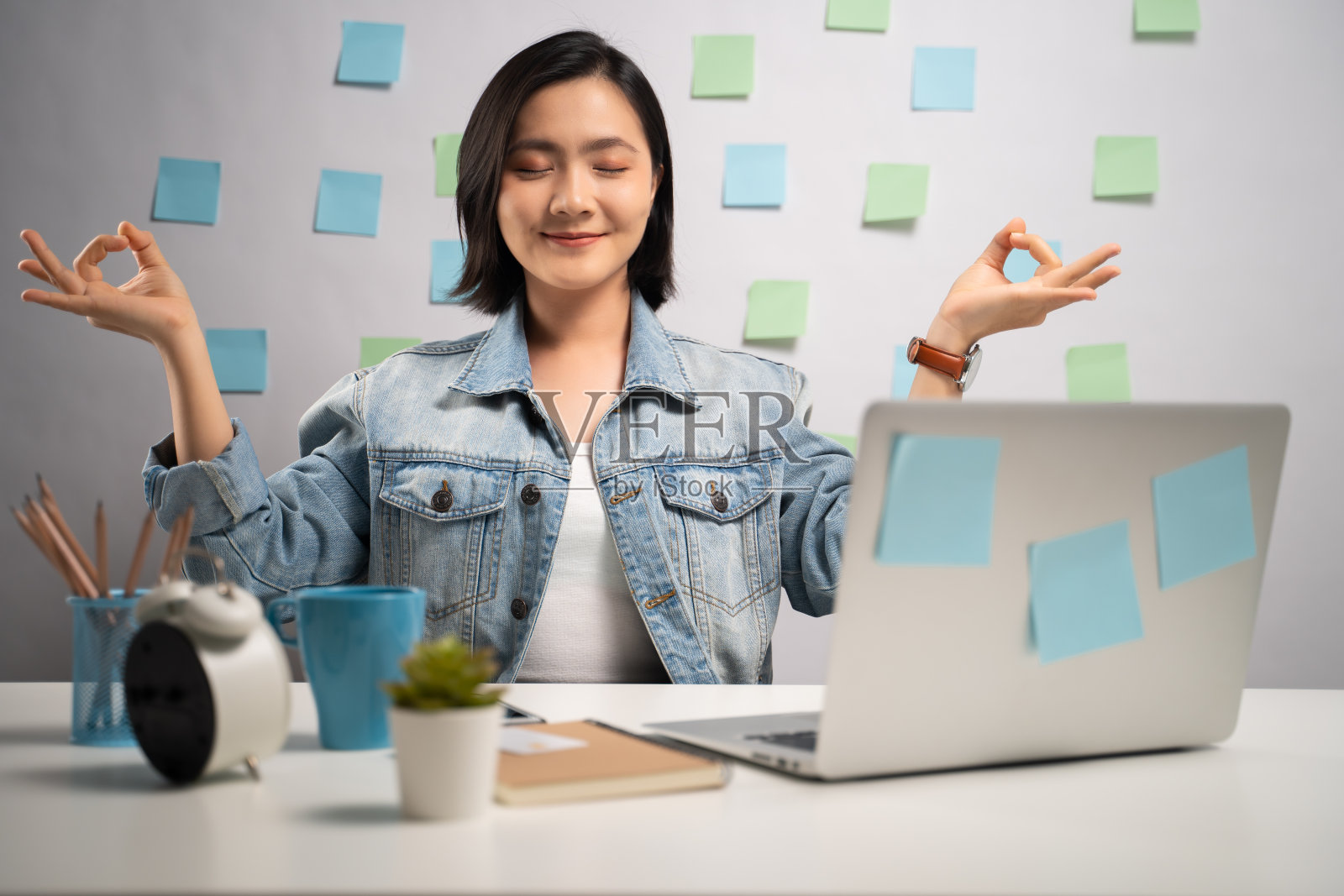 亚洲女性平静下来，深呼吸冥想握着她的手在家里办公室的笔记本电脑工作后。照片摄影图片