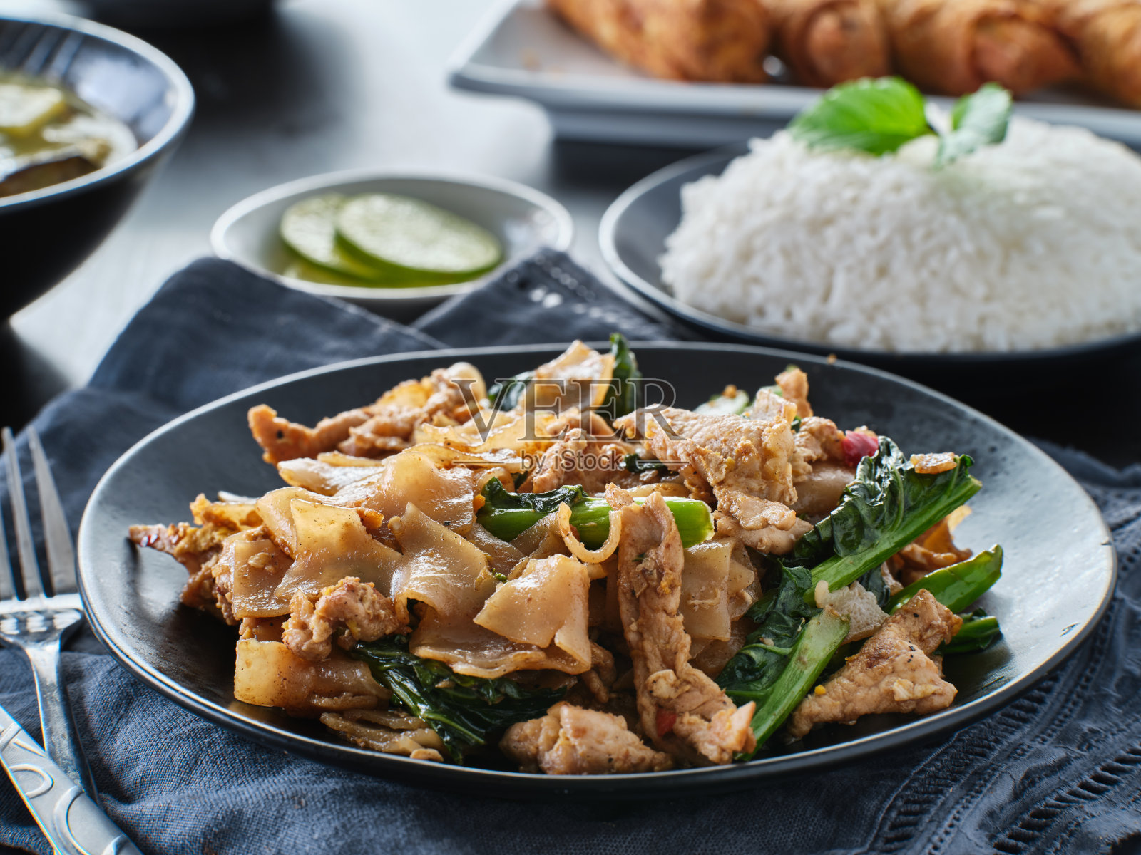 泰式炒面与猪肉和花椰菜一起放在盘子里照片摄影图片