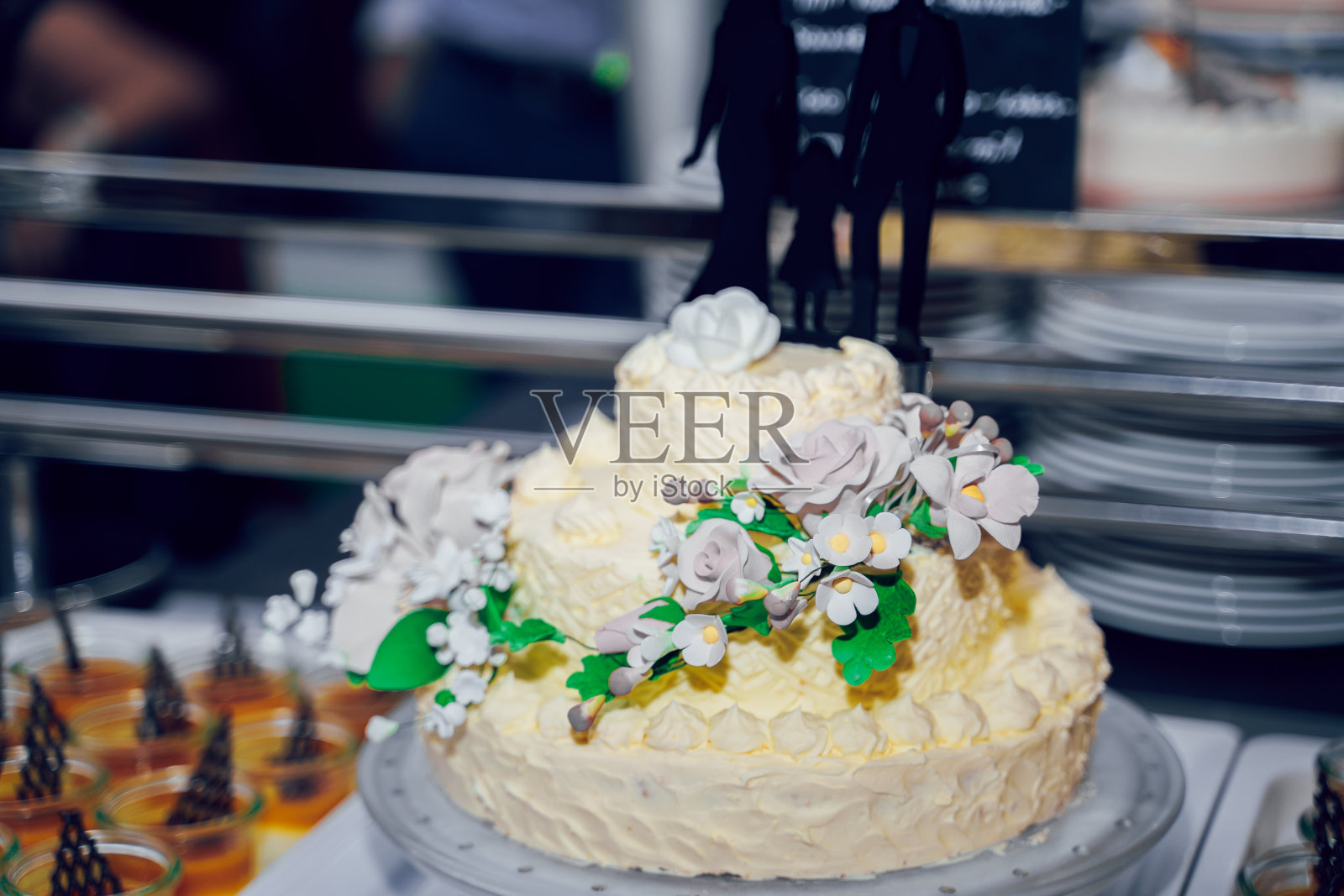 带玫瑰的白色婚礼蛋糕。仪式餐饮。照片摄影图片