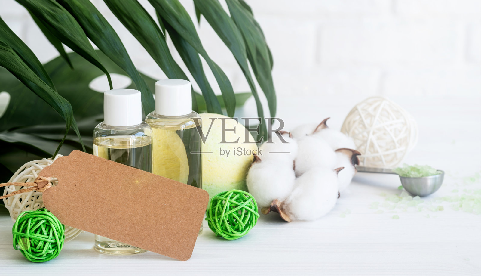 白色的桌子上放着一瓶含有身体护理成分的天然乳液照片摄影图片