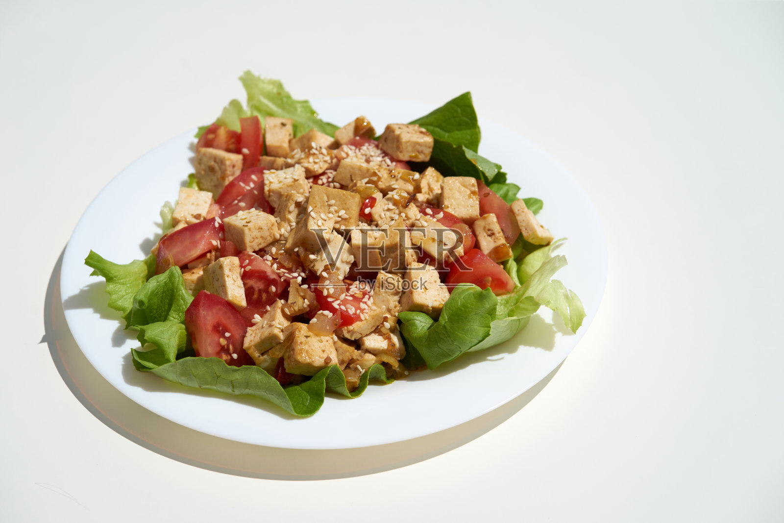 素菜芝麻炒豆腐，白盘白底照片摄影图片