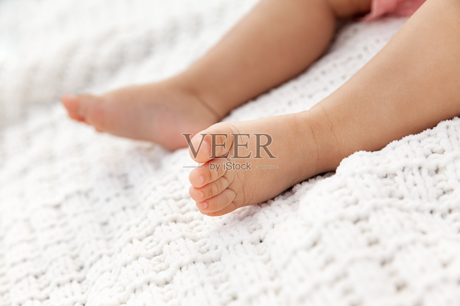 婴儿腿的特写针织白色毯子作为背景在自然光照片摄影图片