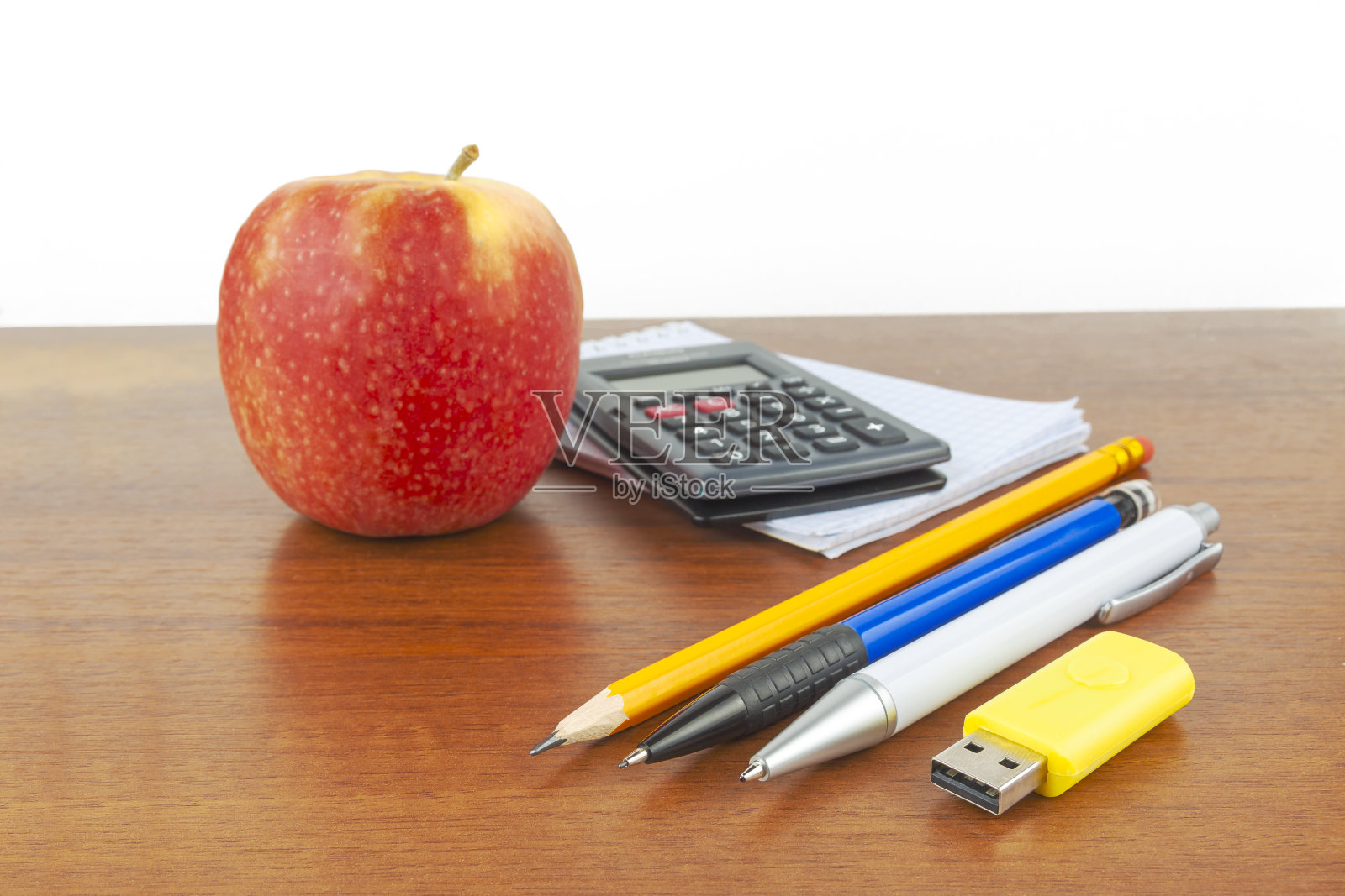 桌上放着苹果笔、笔记本、计算器。照片摄影图片