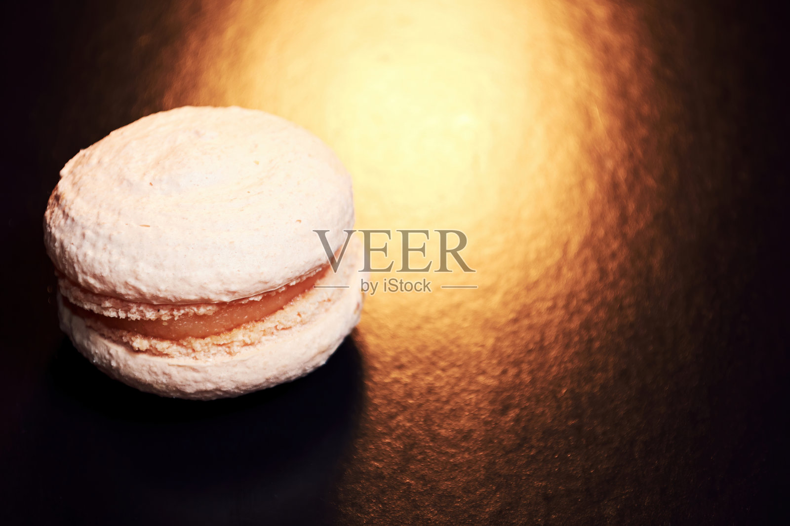 在温暖的灯光下，美味的粉色烤杏仁饼干。美味的食物。食物和饮料背景与复制空间为您的文本照片摄影图片