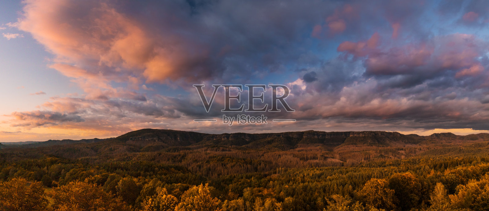 秋天的风景日落-山，森林和美丽的云被夕阳照亮，山波西米亚瑞士照片摄影图片