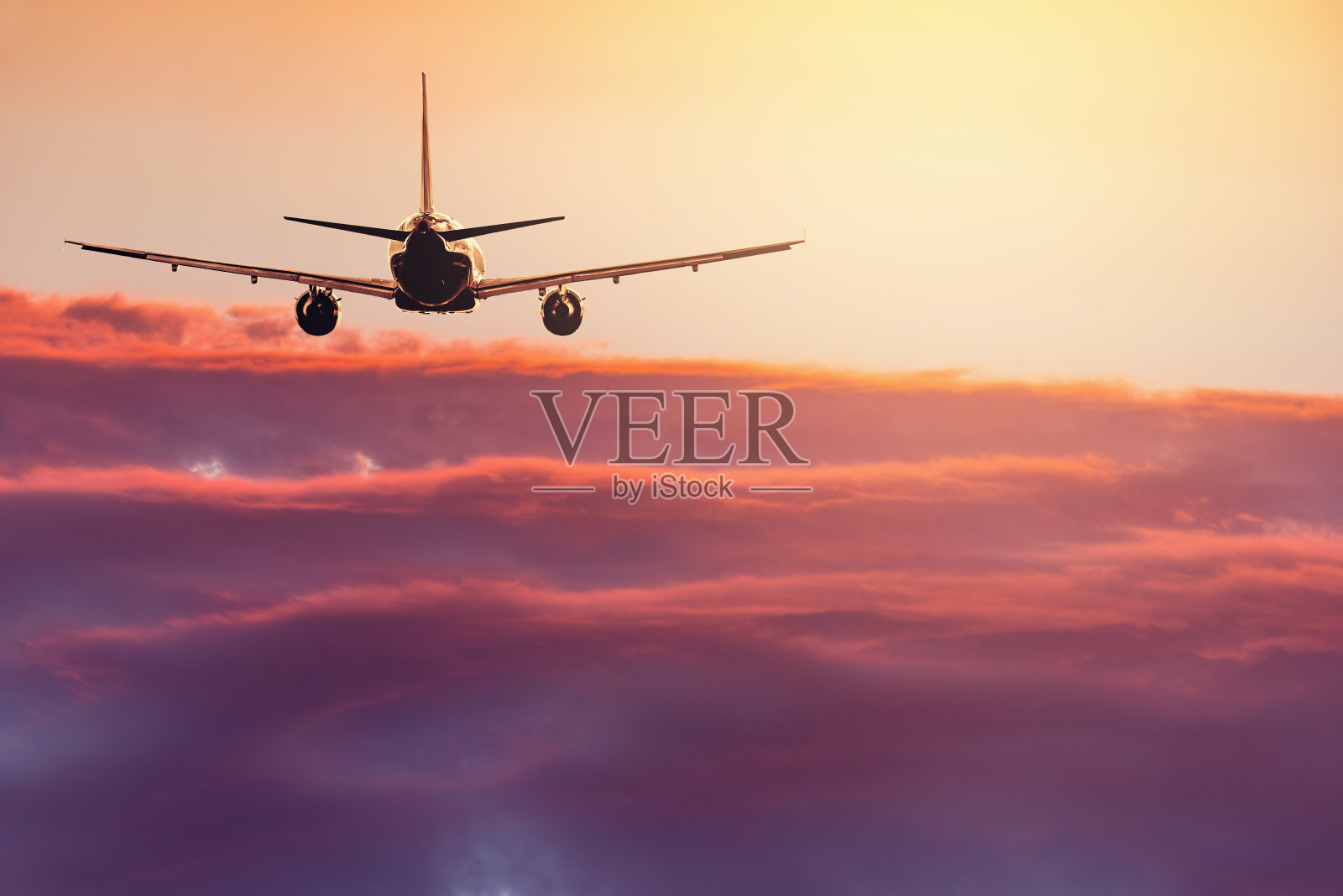 客机在夕阳西下的天空上空飞行。照片摄影图片