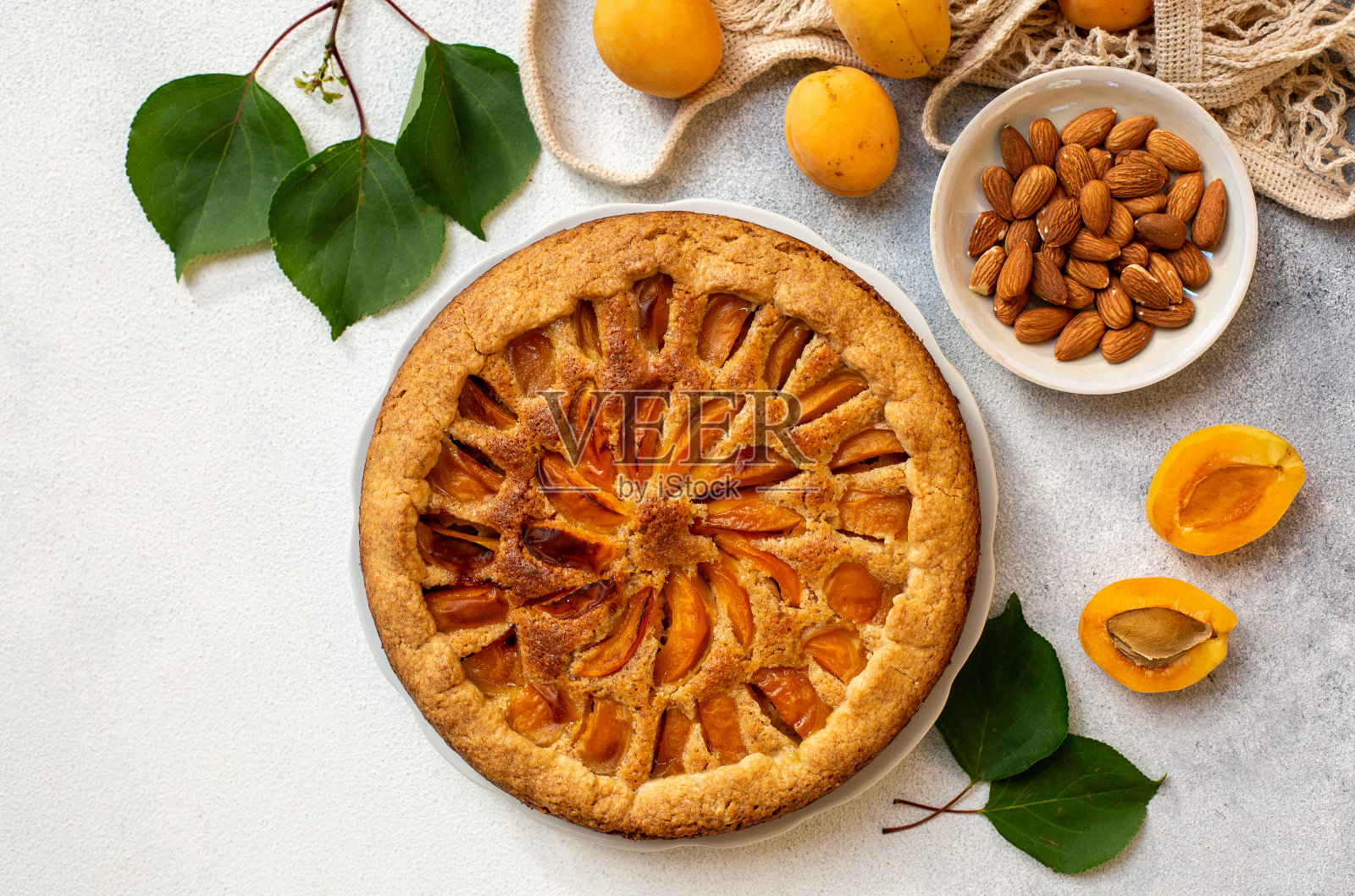 自制杏子蛋挞。杏仁做成的鸡蛋花。白色背景。照片摄影图片