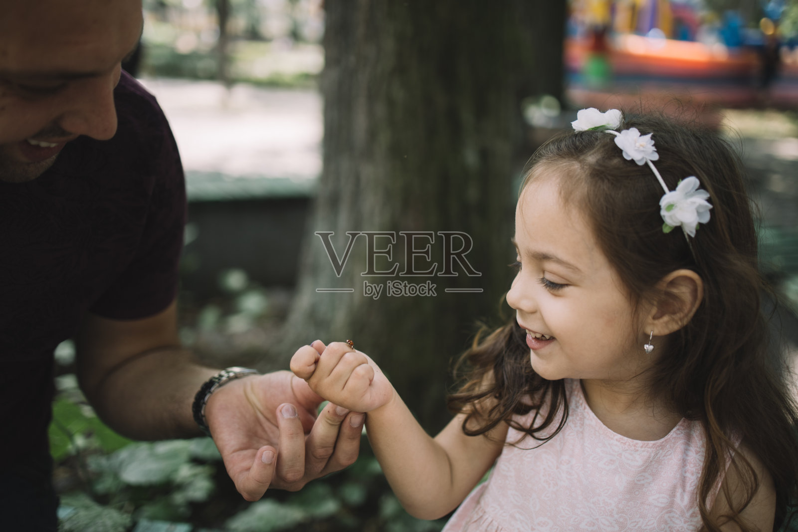 父亲和女儿微笑着玩瓢虫照片摄影图片