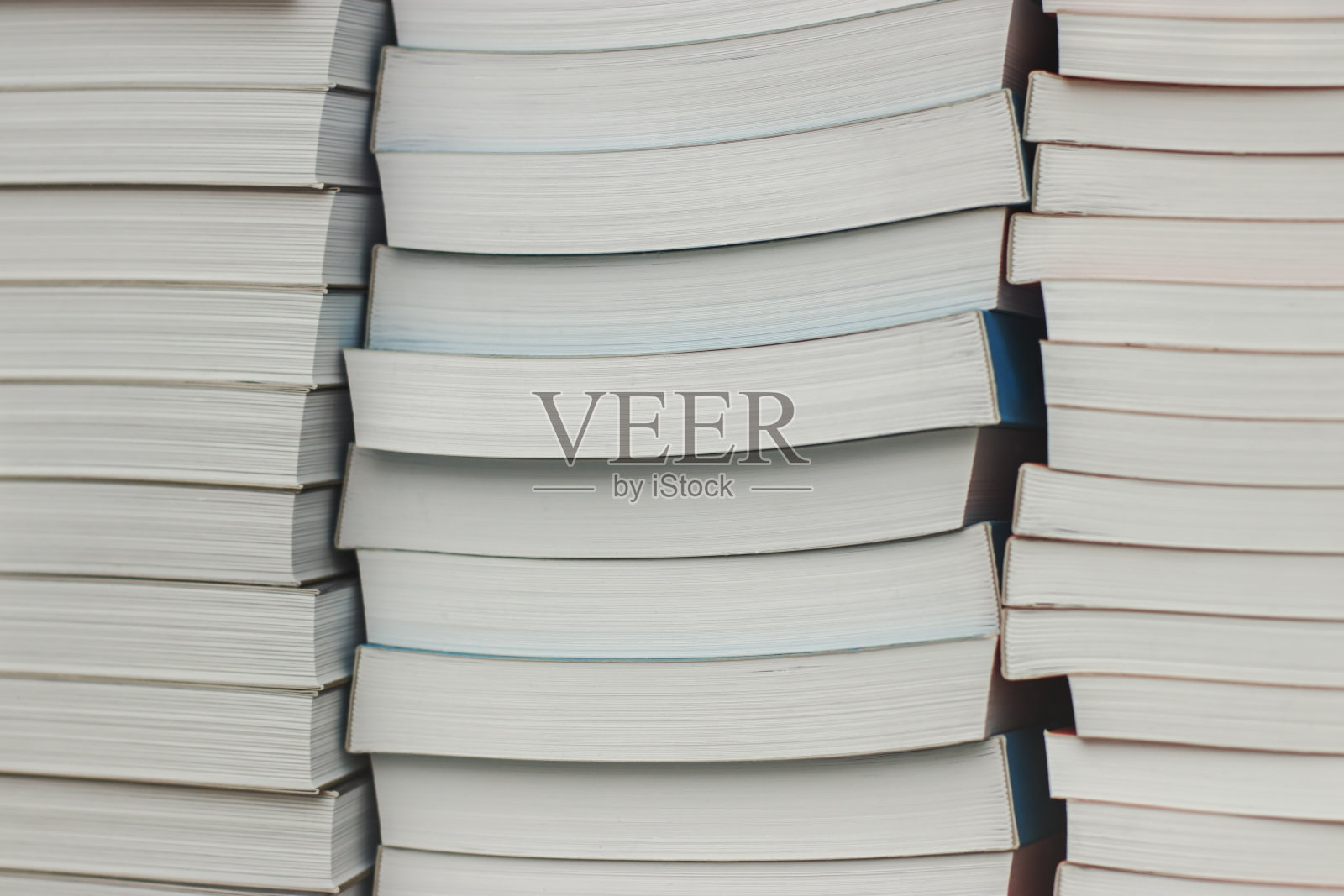 许多相同的书堆叠在一起。照片摄影图片