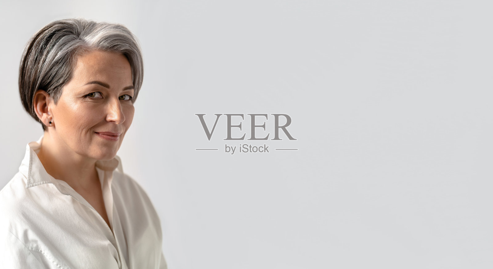 白人中年妇女微笑看着孤立的照相机在白色的背景。特写肖像。复制spase文本。广告横幅的水平空白。成熟的概念照片摄影图片