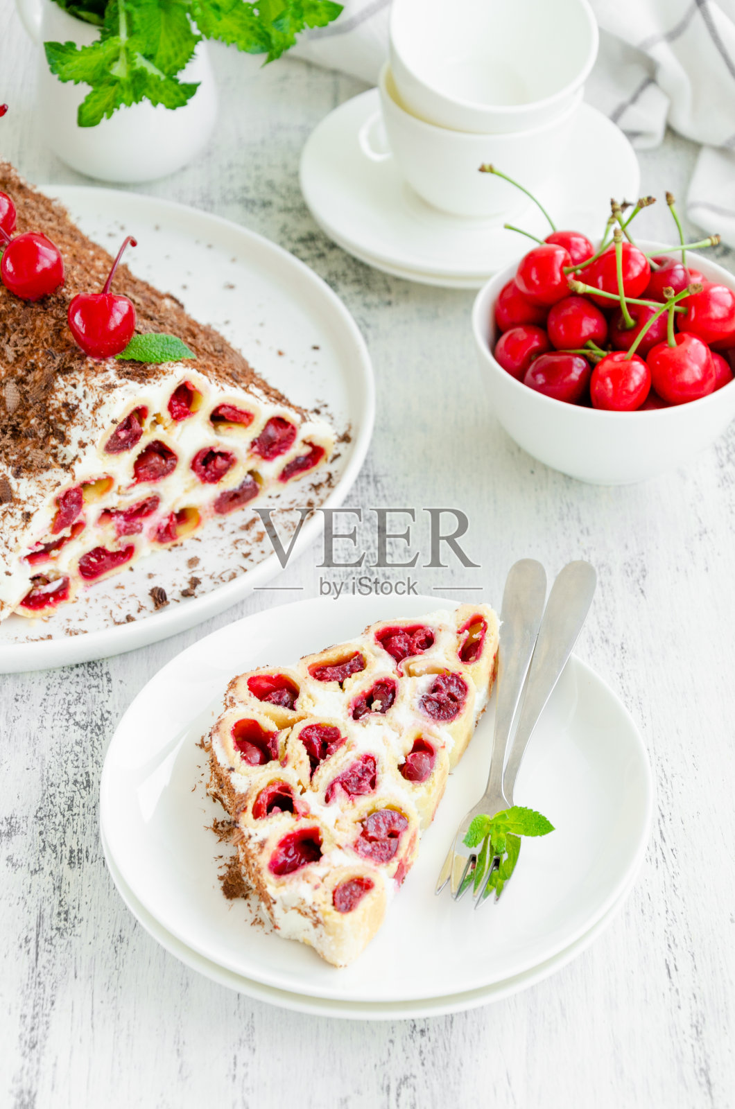 木制背景上的白色盘子上有樱桃、酸奶油和巧克力自制蛋糕。垂直,复制空间。照片摄影图片