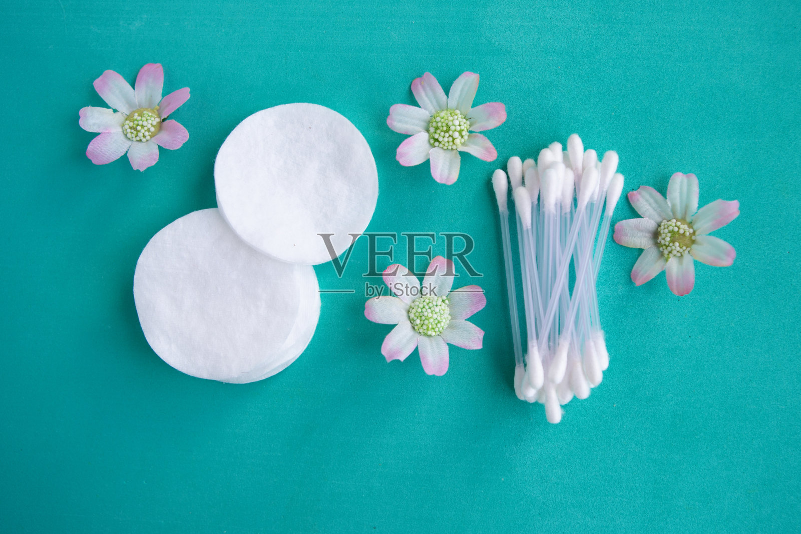 棉海绵和棉签在绿色背景上，俯视图照片摄影图片