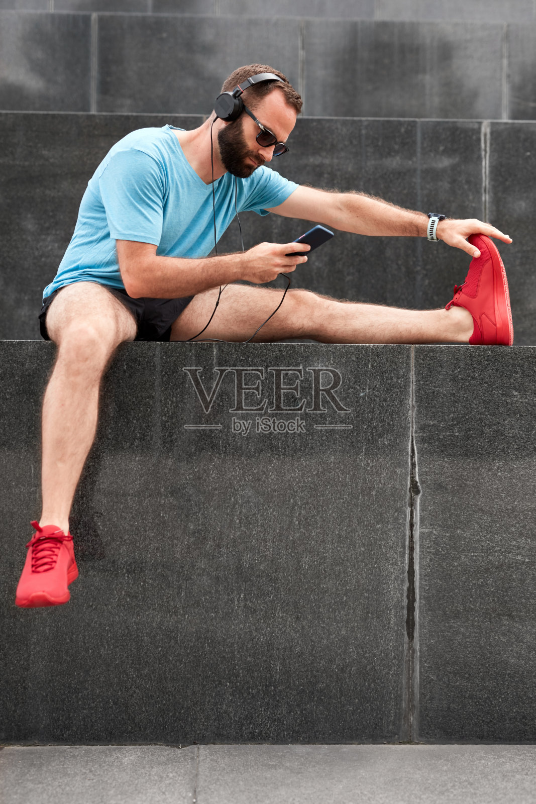 现代运动员在城市环境中慢跑/锻炼后停下来伸展身体。照片摄影图片