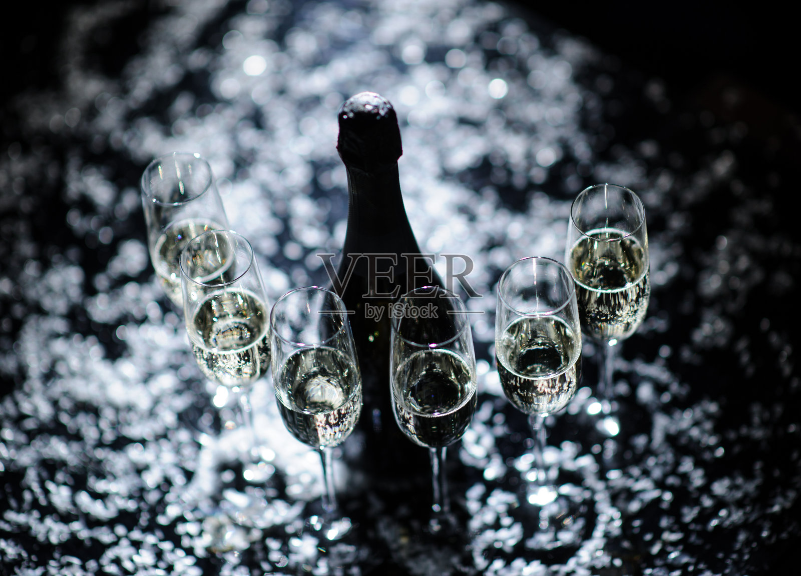 庆祝新年、生日、圣诞晚会。黑色背景的桶里的香槟。圣诞老人的帽子照片摄影图片