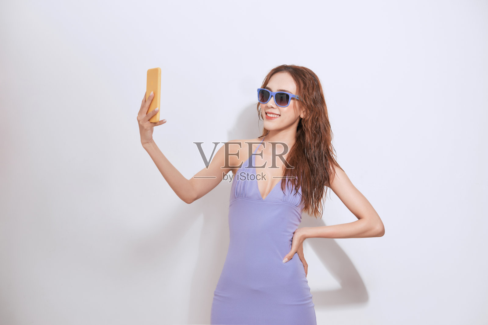 漂亮的年轻亚洲女人站在和自拍孤立在白色的背景。照片摄影图片