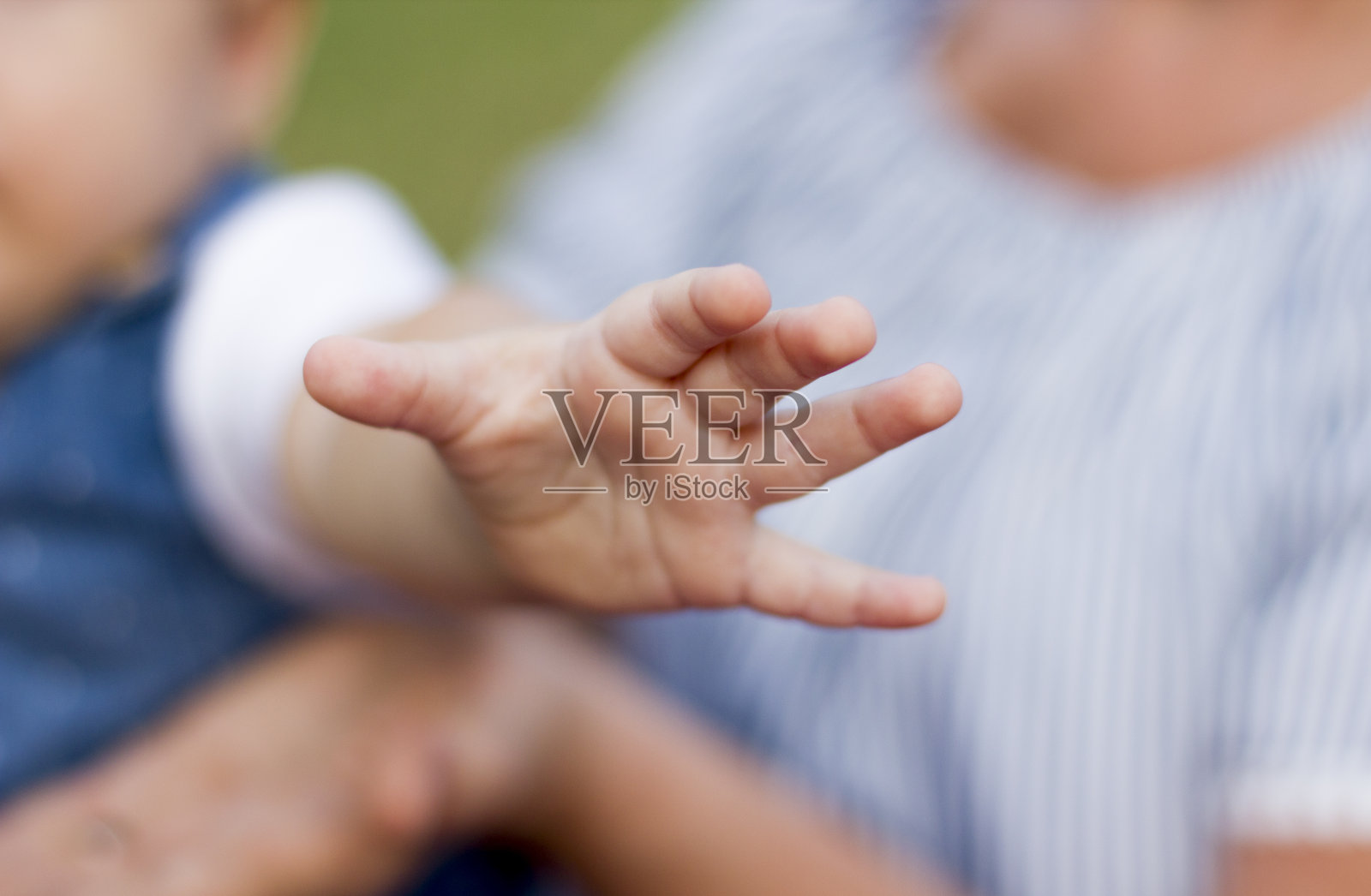 一位欧洲人的祖母带着一岁的孙女在绿色的公园里散步。照片摄影图片