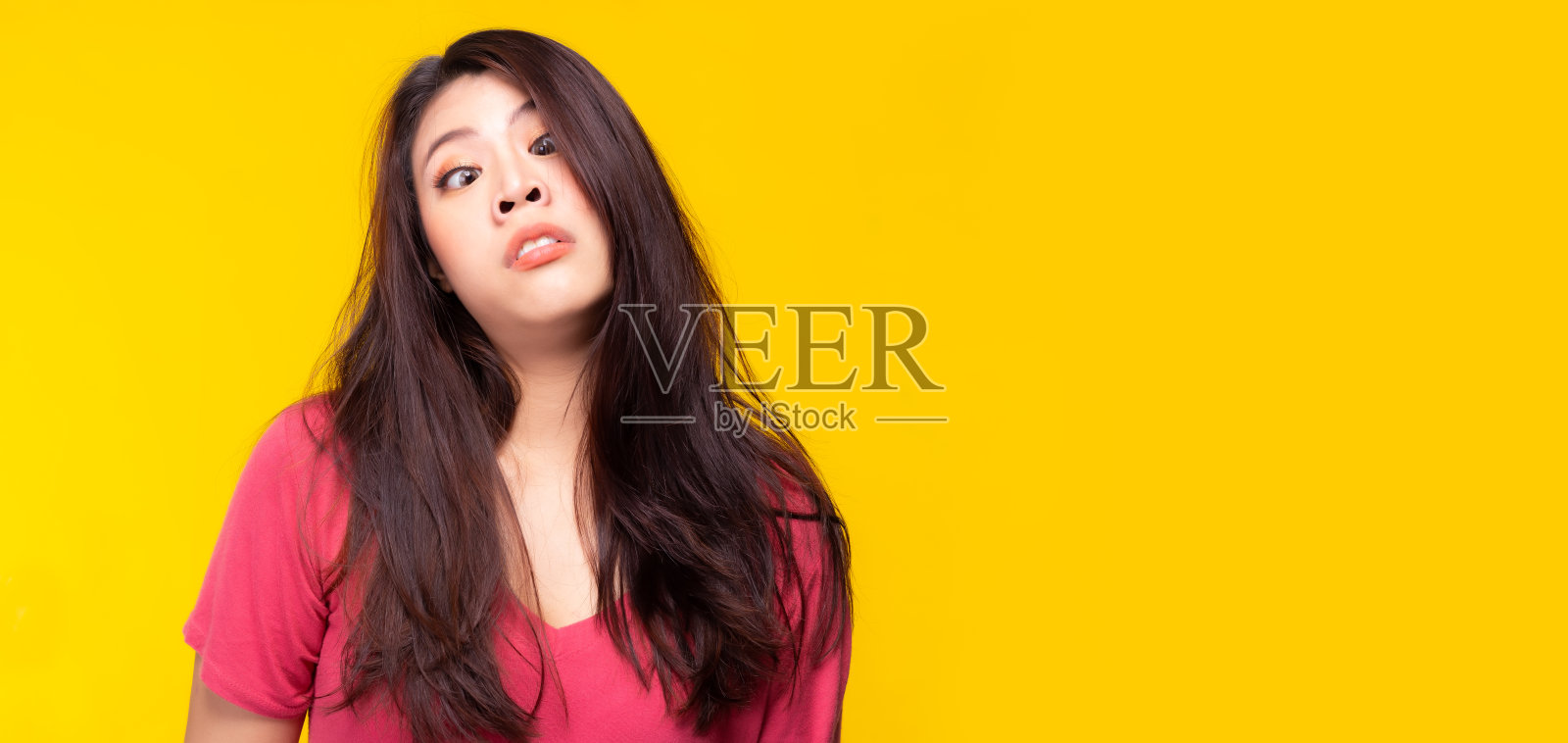 傻傻的女孩在愚人节做鬼脸穿过四月眯着眼睛。年轻女人做傻瓜面部表情斗鸡眼女人与奇怪的表情。女人失去了她的疯狂的脸女人照片摄影图片