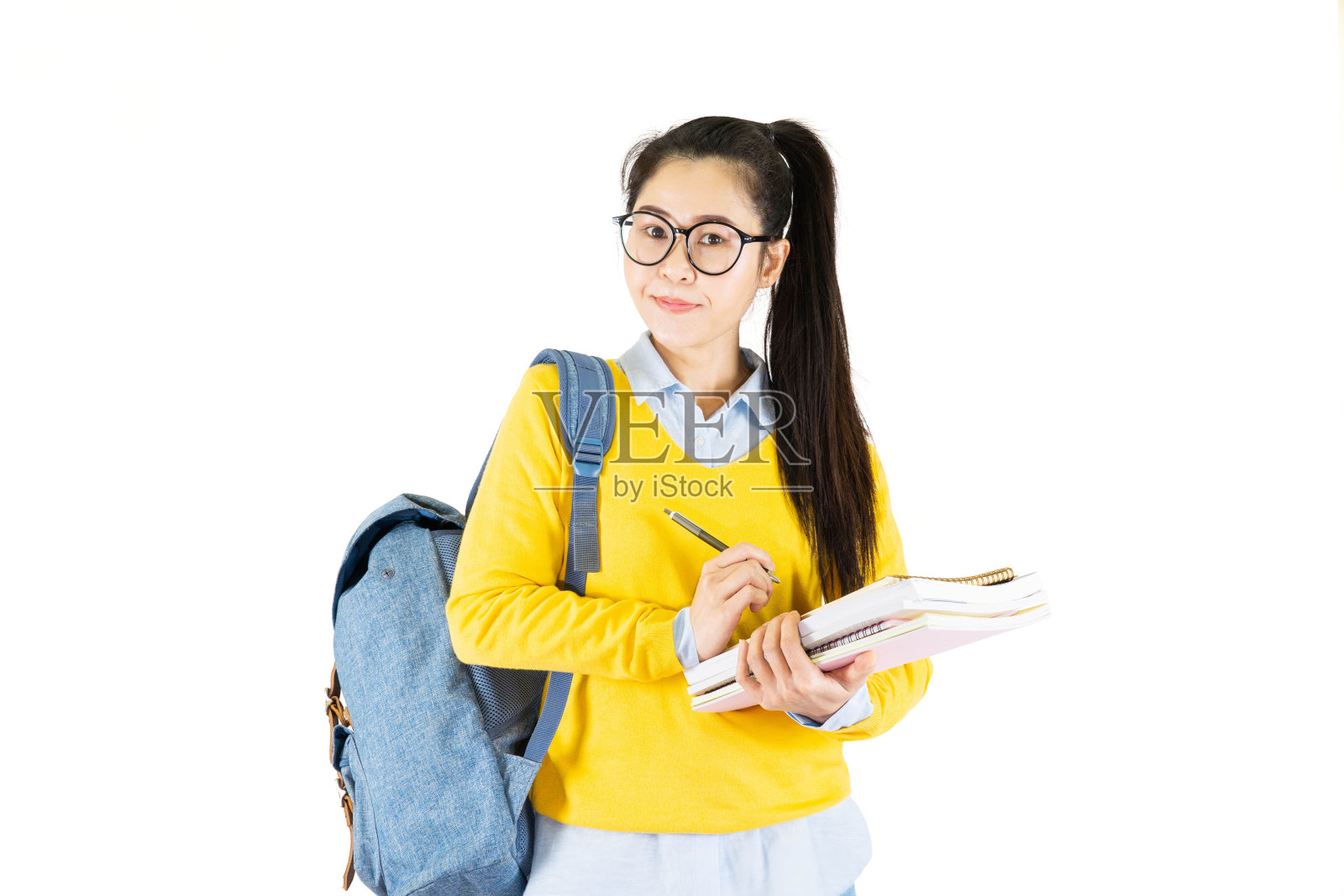 一个快乐友好随意的女学生亚洲人在眼镜与背包拿着书和笔孤立在白色的背景照片摄影图片