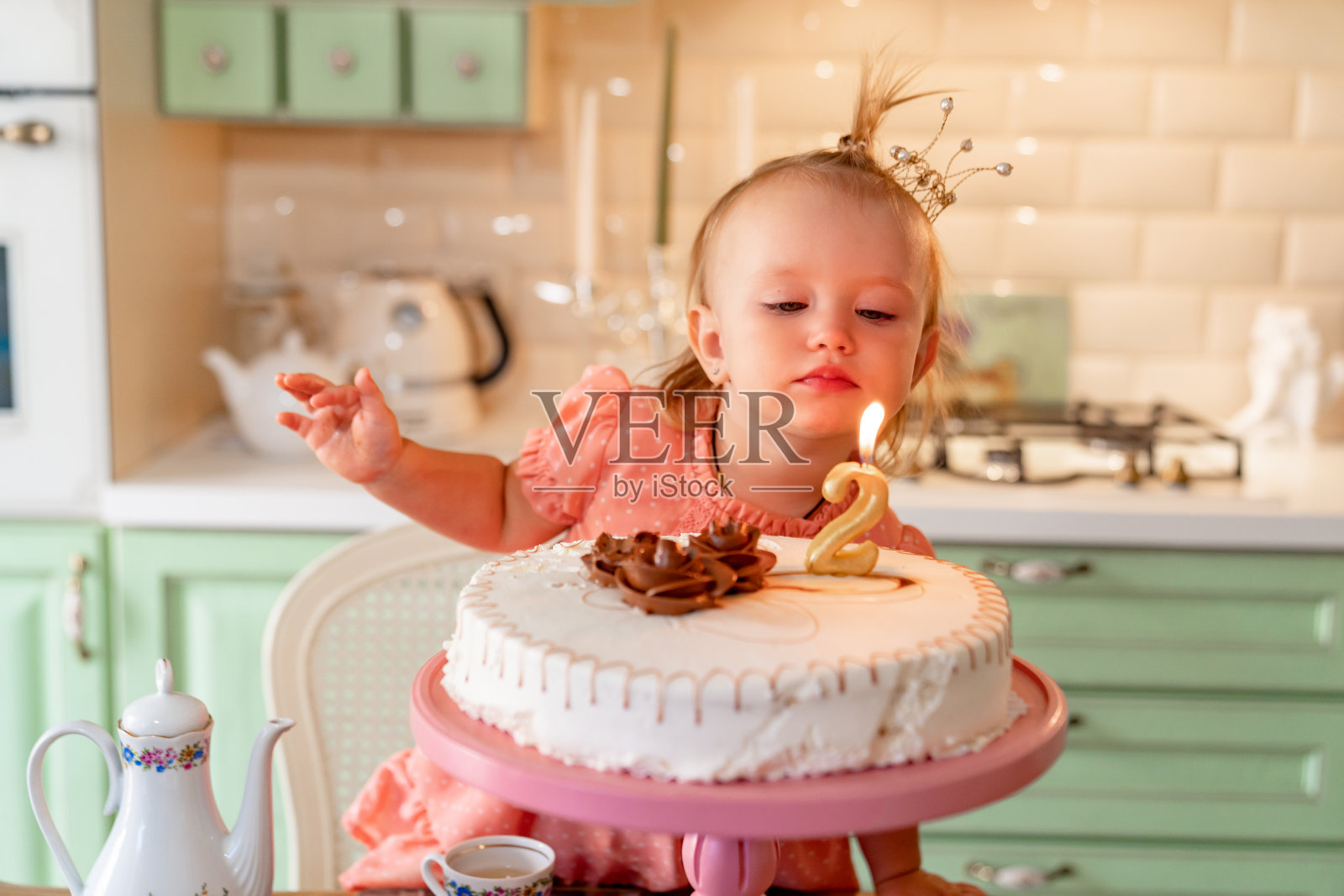 小女孩在家厨房里吃着蛋糕。家人回家两年生日。照片摄影图片