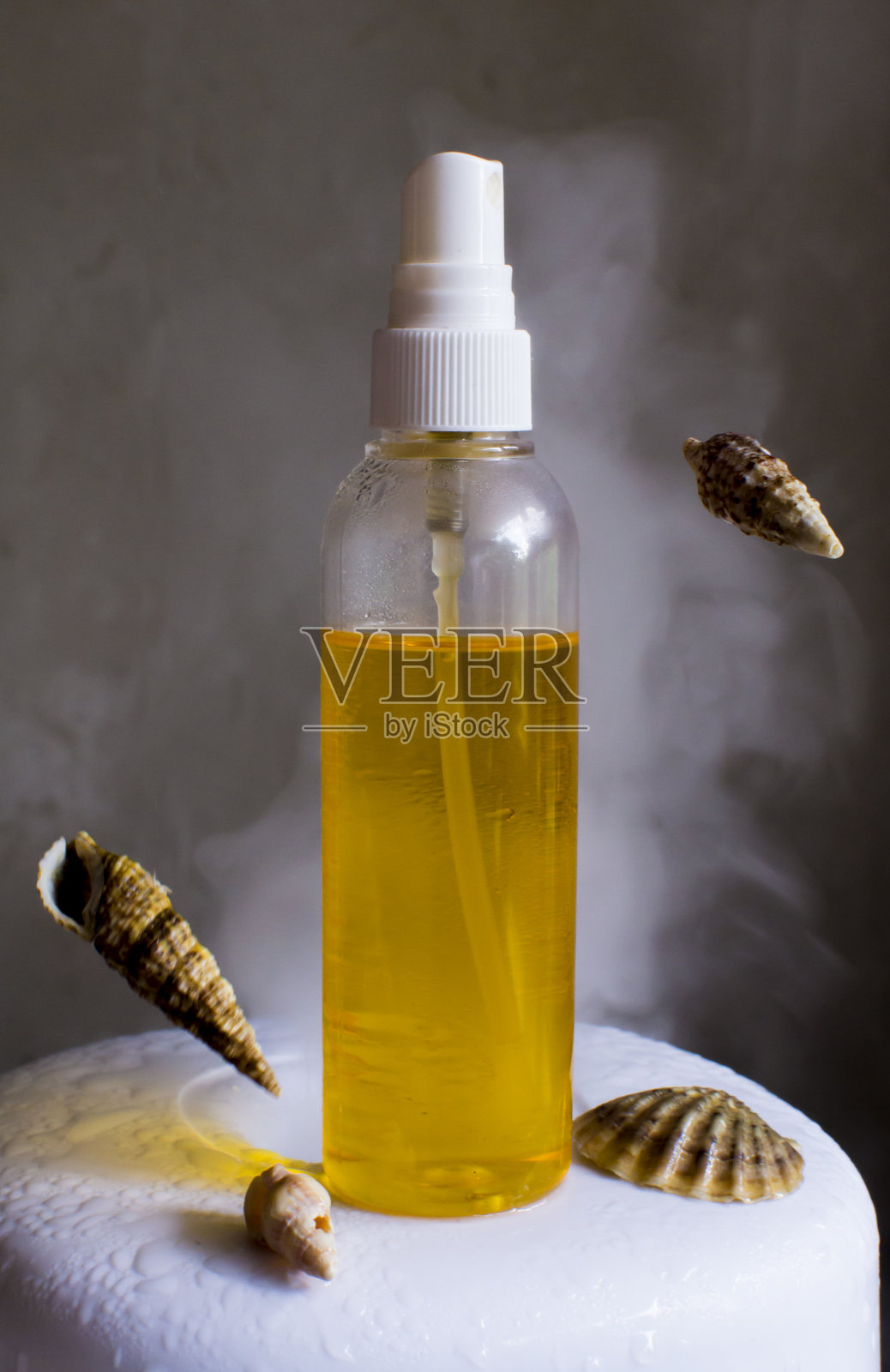 按摩油。Spa芳香疗法。喷雾晒黑。海洋的概念。背景中有蒸汽。照片摄影图片