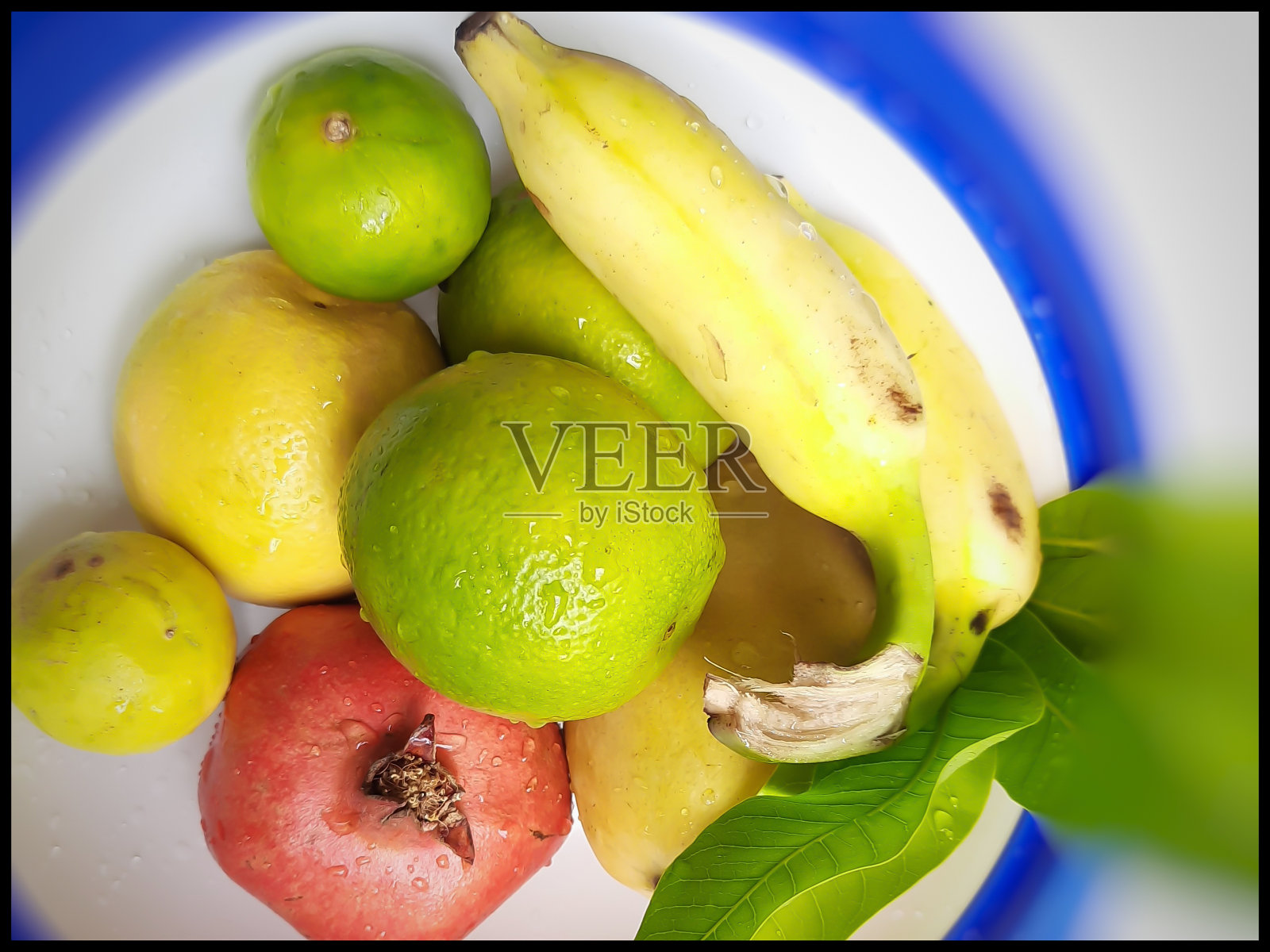 健康的水果保存在漂亮的白色碗，与树叶和健康的食物和维生素c健康的日常水果排列照片摄影图片