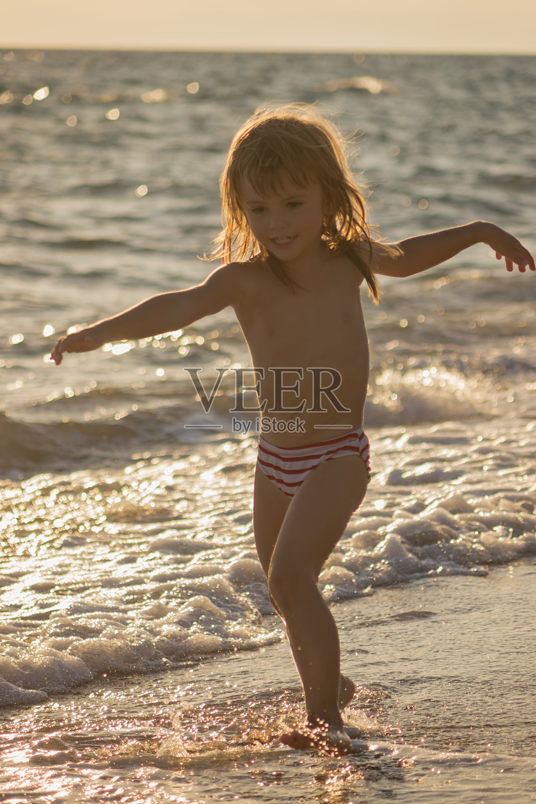 小女孩在浅滩上奔跑照片摄影图片