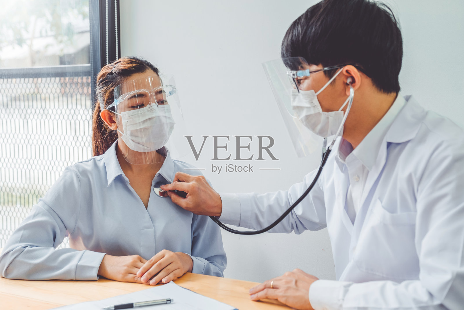 冠状病毒流行后，医生戴上口罩和眼镜安慰和护理病人，在护理病房给予帮助、鼓励和同情。照片摄影图片