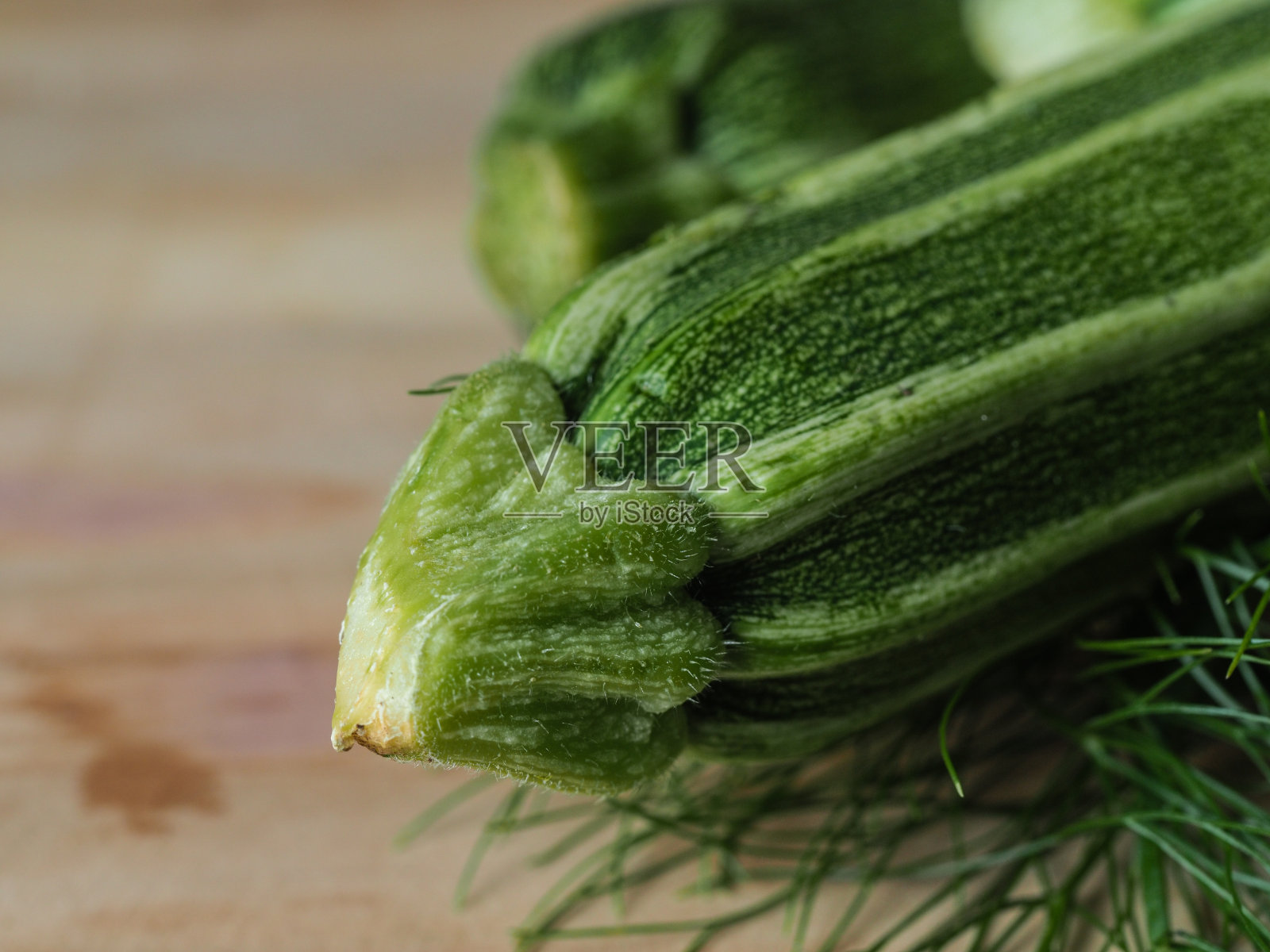 头顶拍摄的一组孤立的三种绿色生物西葫芦蔬菜水果在浅棕色的桌子和一个纸回收袋复印空间照片摄影图片