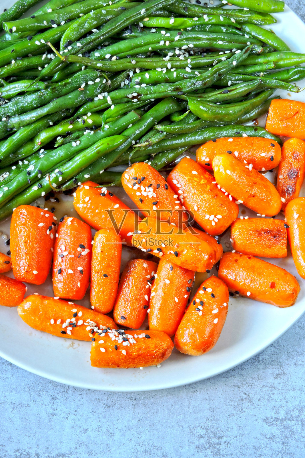 青豆和小胡萝卜，放在烤架上烤。照片摄影图片