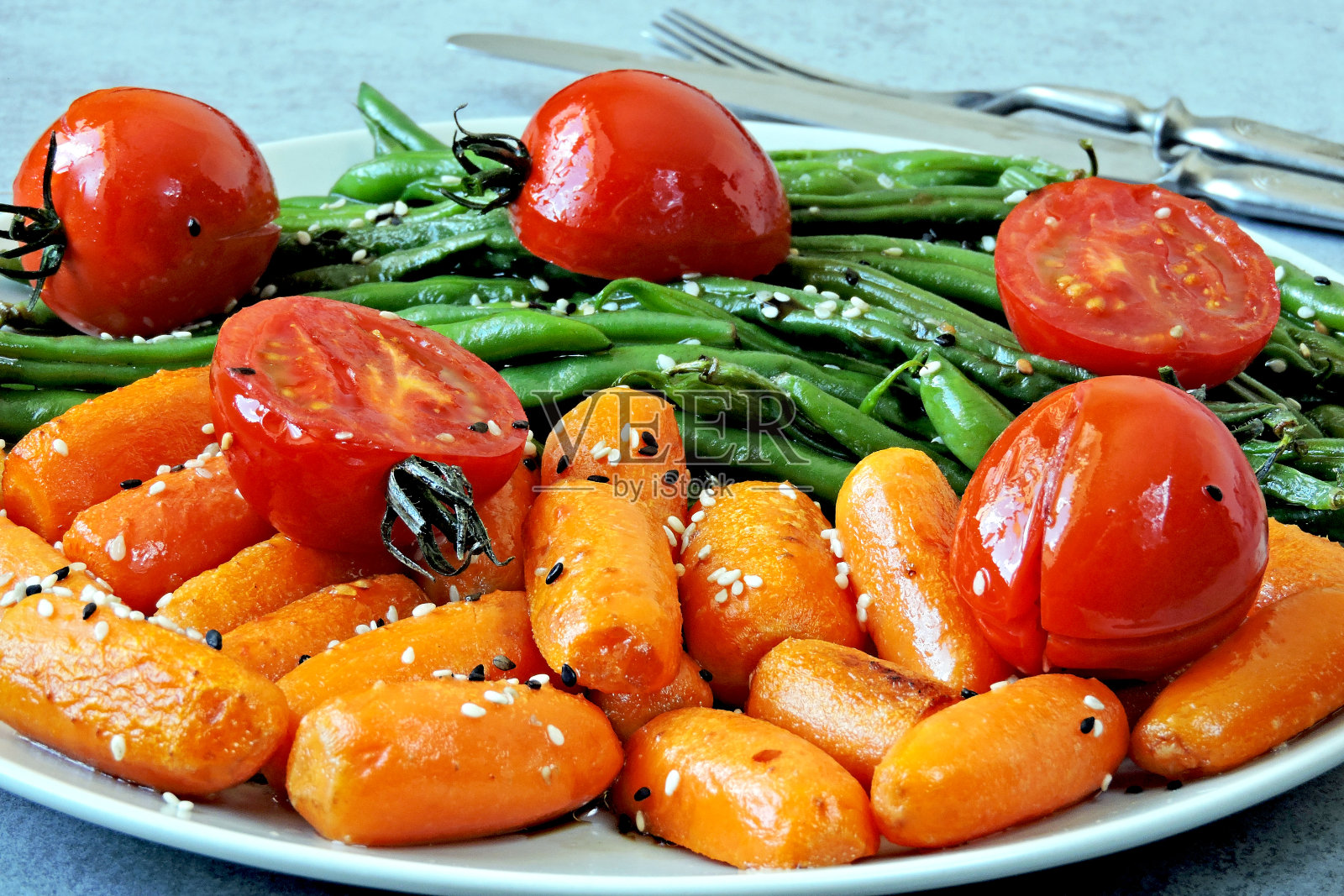 青豆和小胡萝卜，放在烤架上烤。照片摄影图片