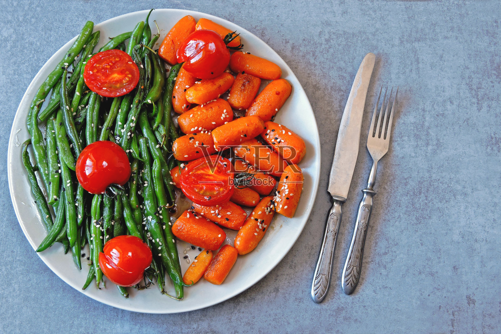 青豆和小胡萝卜，放在烤架上烤。照片摄影图片