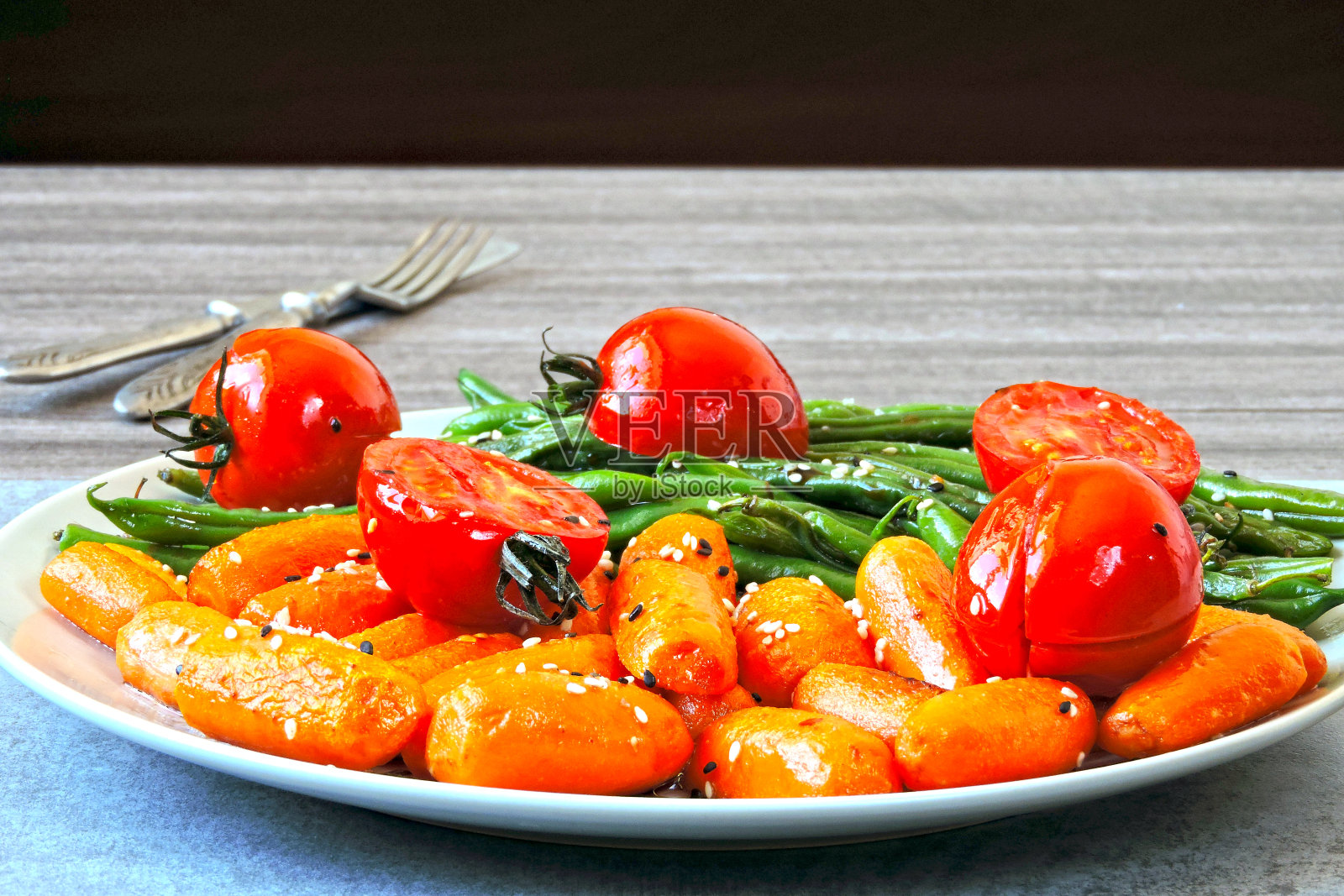 青豆和小胡萝卜，放在烤架上烤。照片摄影图片