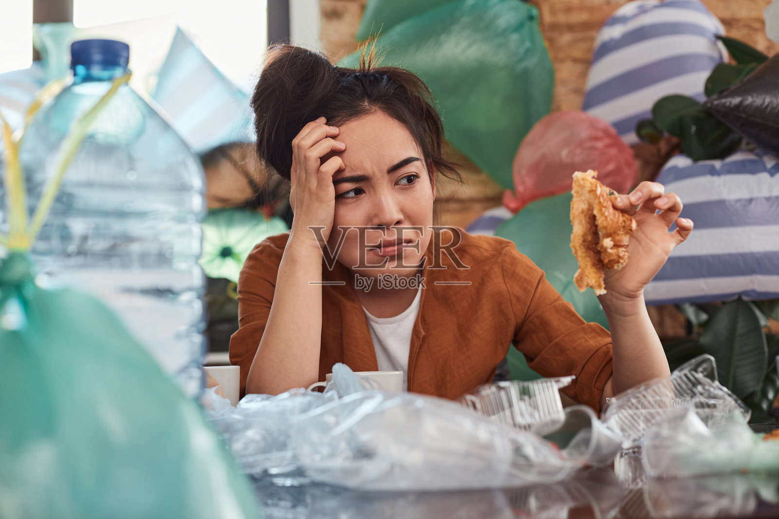 一位头发蓬乱的年轻女性正在把她的公寓变成垃圾堆照片摄影图片