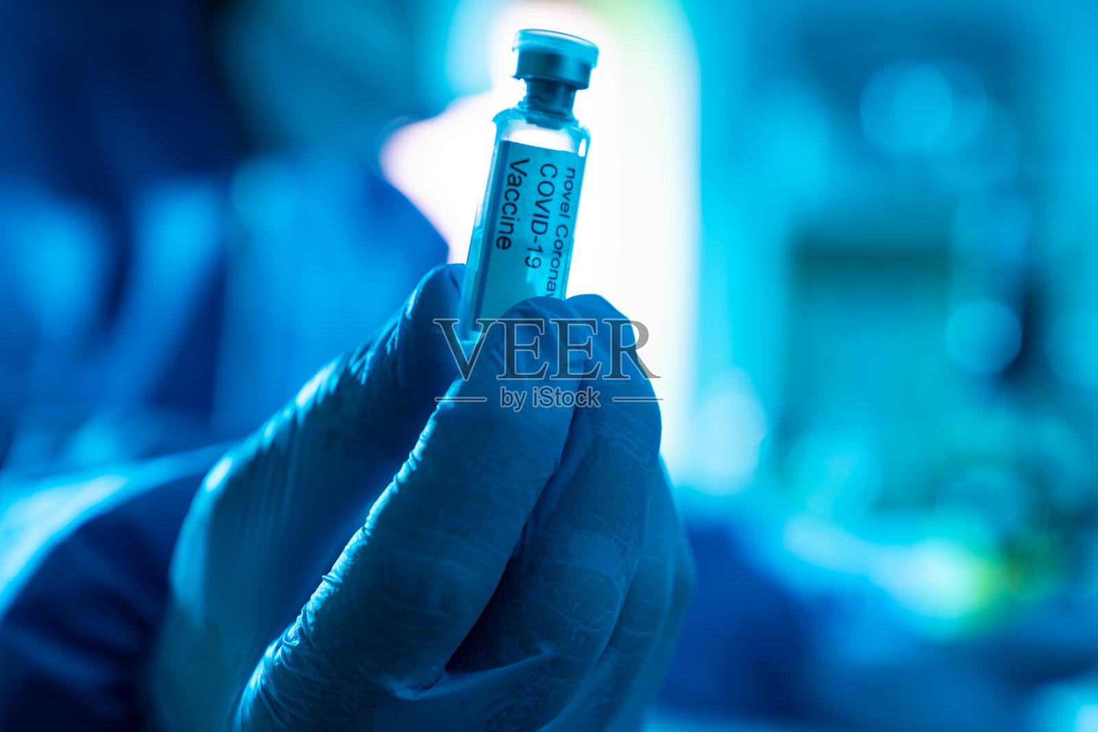 戴手套的手拿着新冠病毒Covid-19疫苗玻璃瓶照片摄影图片